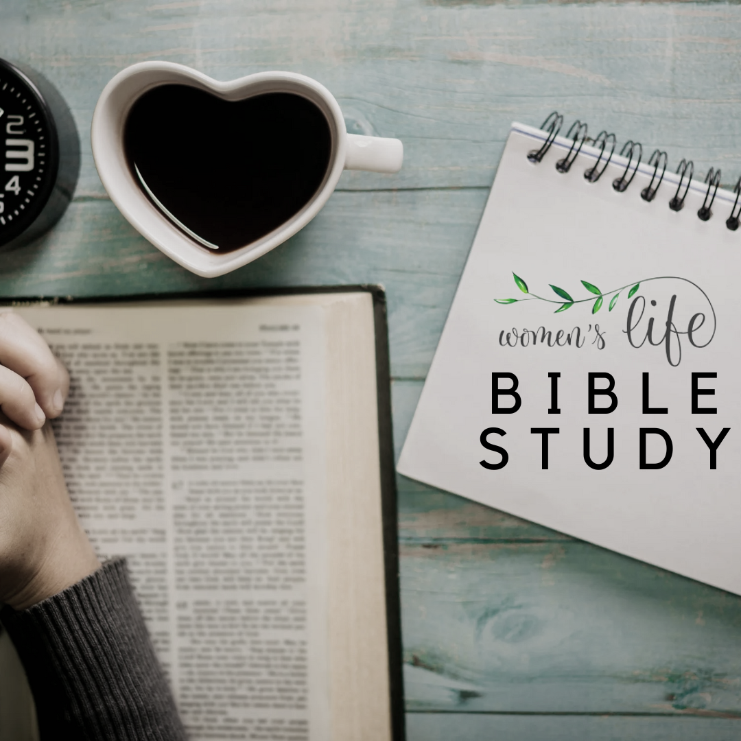 A flat lay of a woman's Bible study setup with an open Bible, a person's hand with a sweater, a heart-shaped coffee mug filled with coffee, a black alarm clock, and a spiral notebook with 