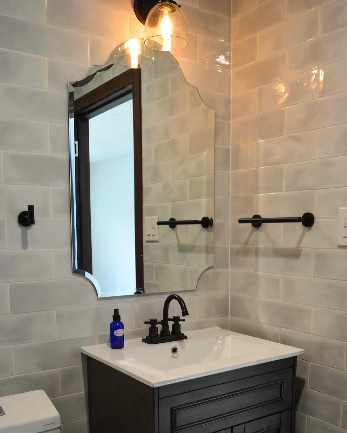 For the powder room all new tile, fixtures, vanity, mirror and sconce. Again we see a color and texture variation in the tile for a hand made feel(but on a budget). The mirror complements the shape of the accent tiles in the downstairs bathrooms (nex