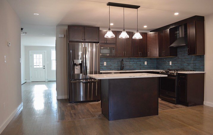 For the kitchen I created contrast by incorporating dark wood with white quartz countertops. The blue tiled backsplash adds a pop of color while creating depth and variation. All black stainless steel appliances pair nicely with antiqued bronze hardw