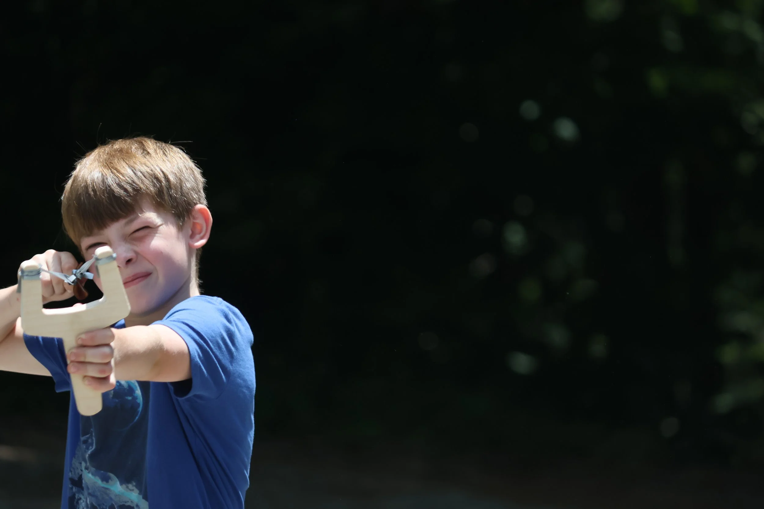 Camper Taking aim with his slingshot. 
