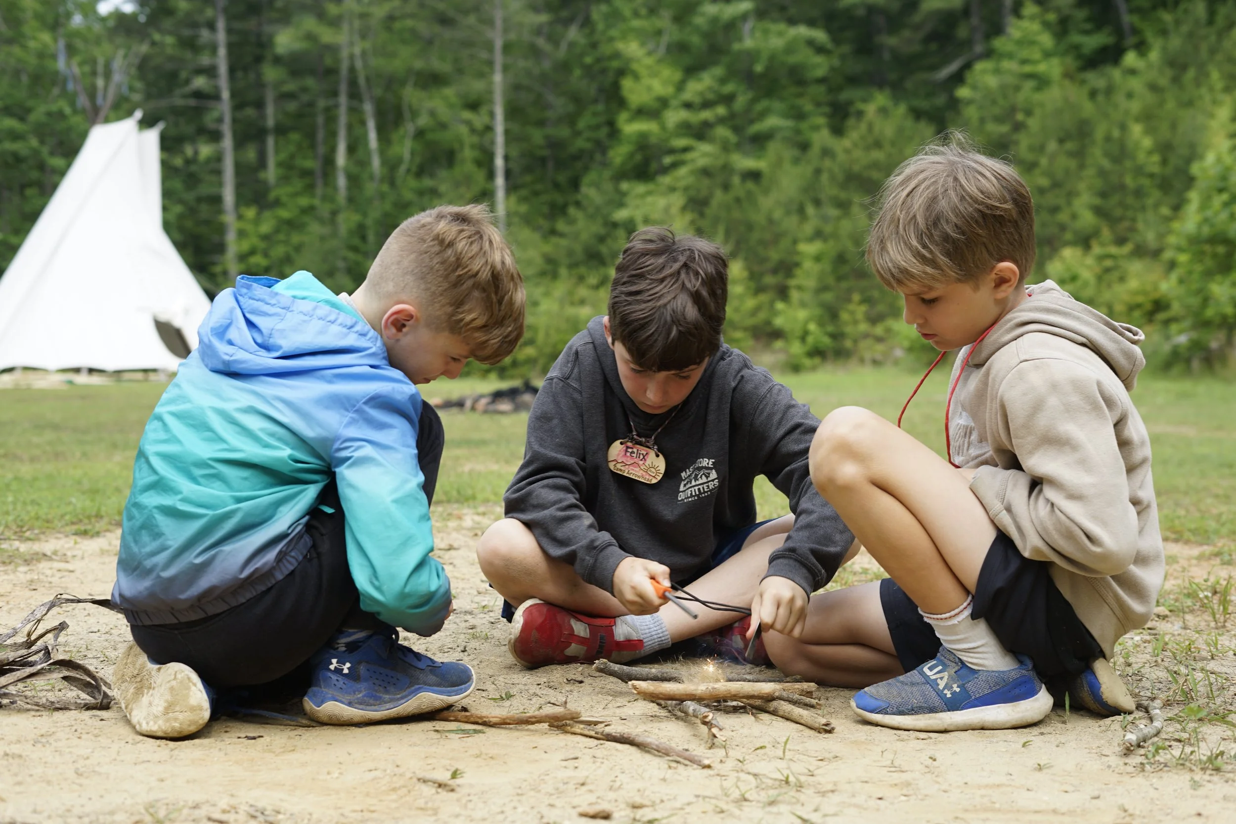 Boys all practicing the art of fire building in North Carolina. 