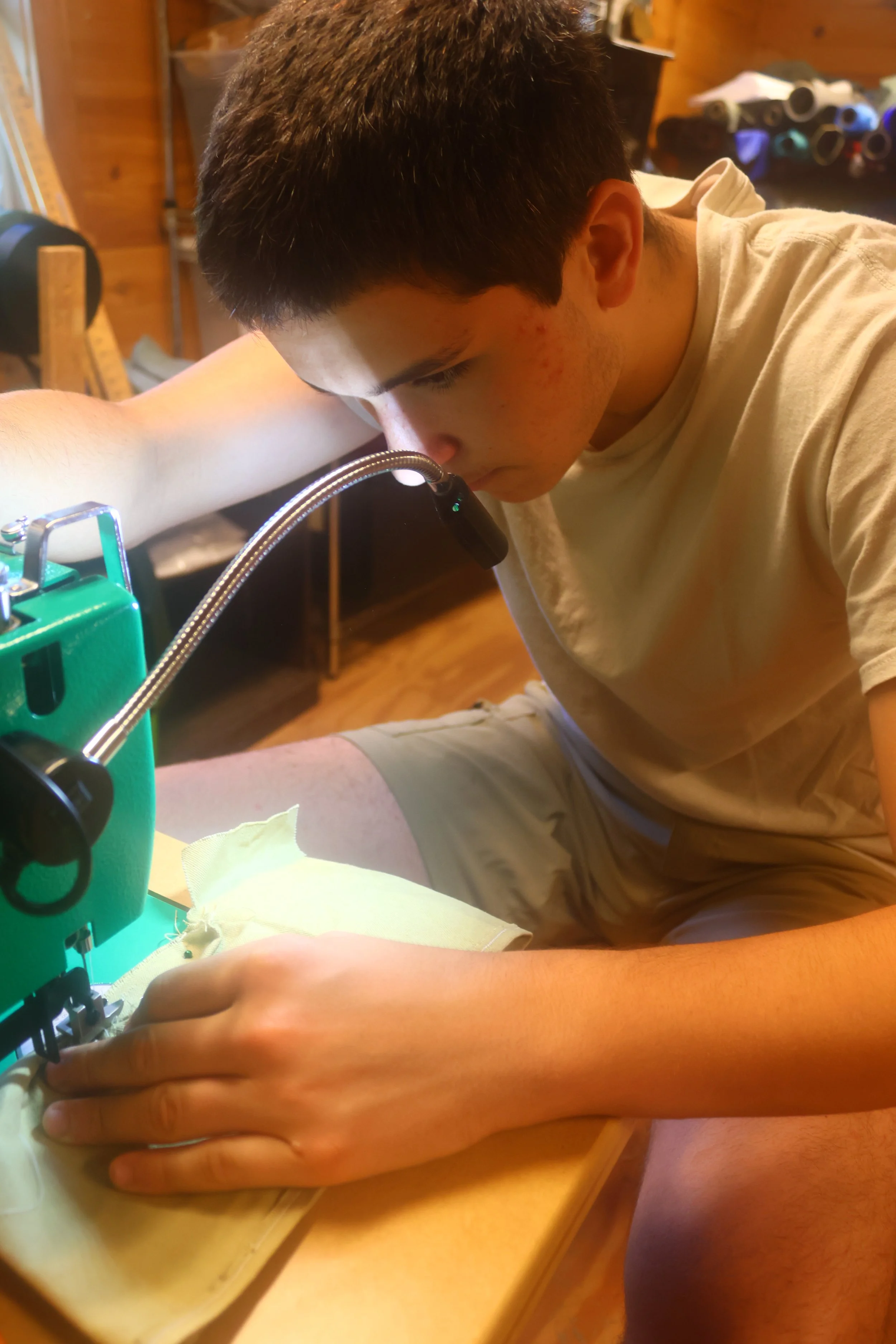 Older Camper sewing with concentration in North Carolina. 