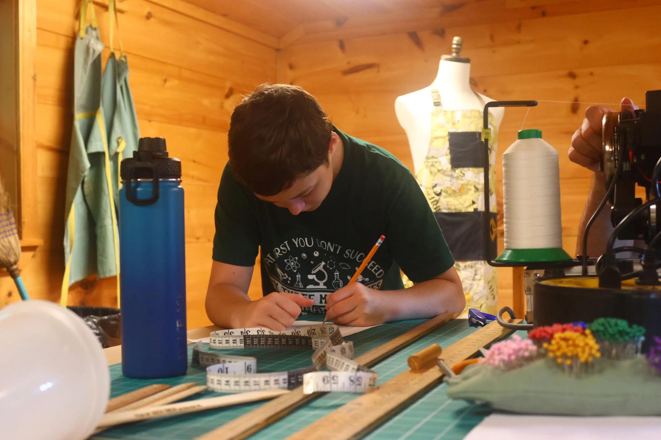 Young Maker laying out his pattern in Threadquarters before sewing.