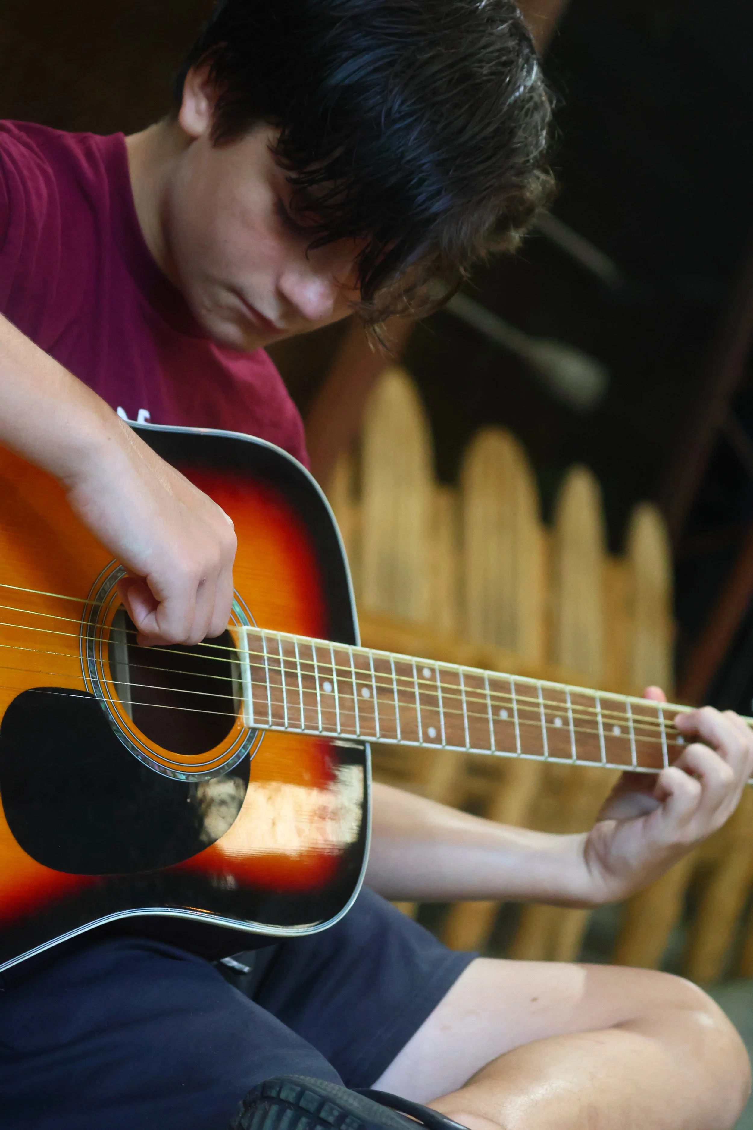 Overnight camper practices guitar in music at Camp Arrowhead in North Carolina. 