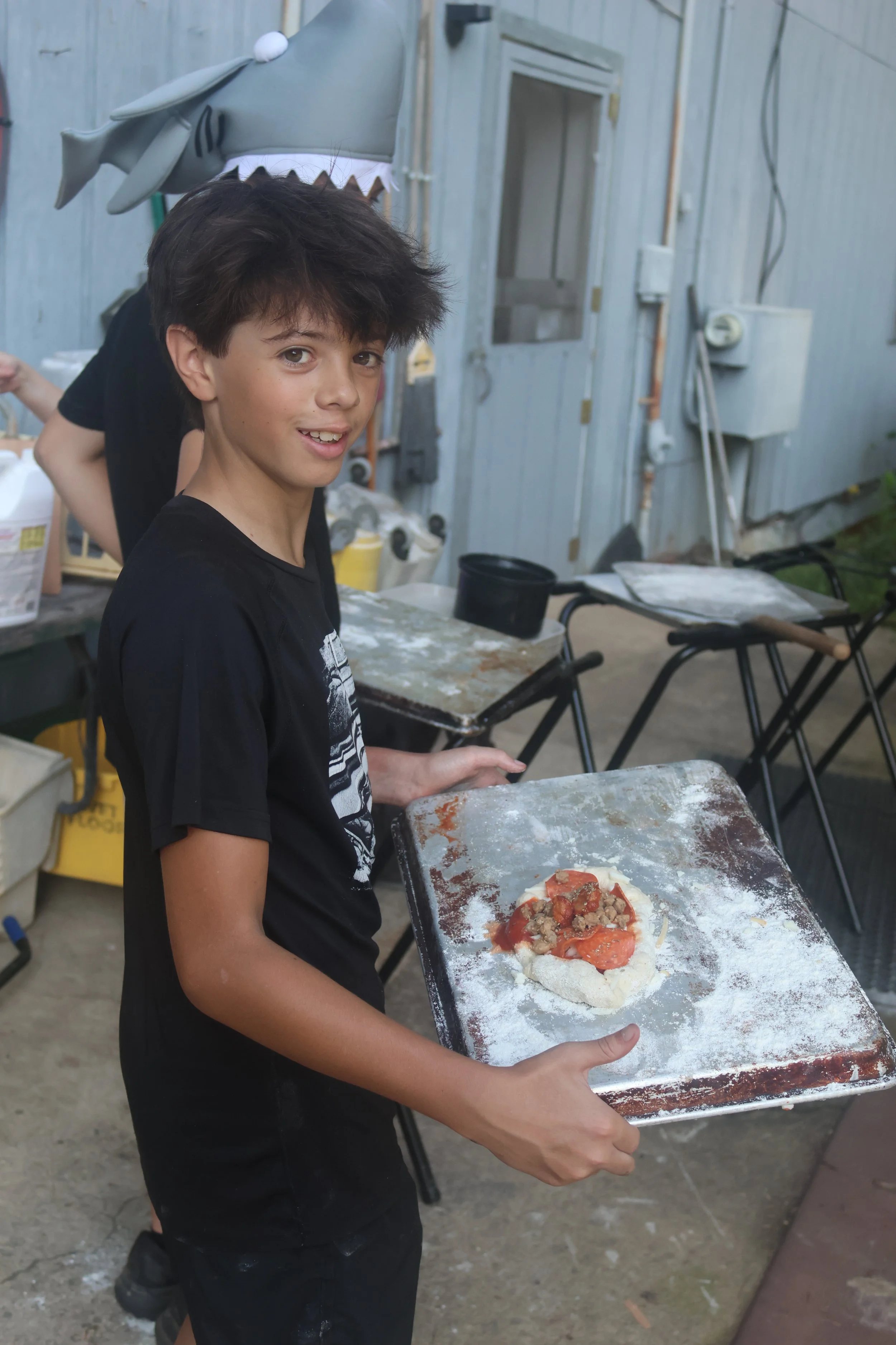 Sleepaway camper makes his own pizza in cooking for the oven at Camp Arrowhead in NC. 