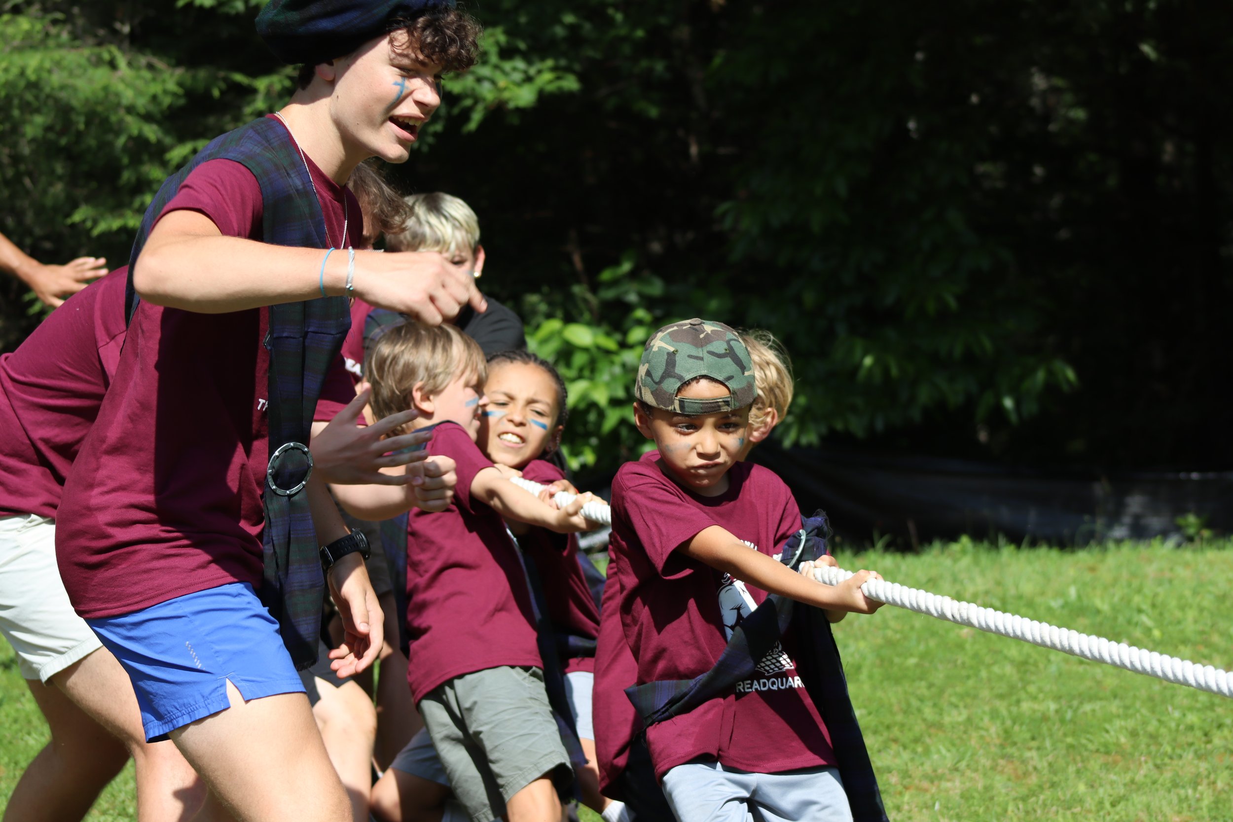 Camp Arrowhead Counselor encouraging his campers at tug of war at Camp in the summer.