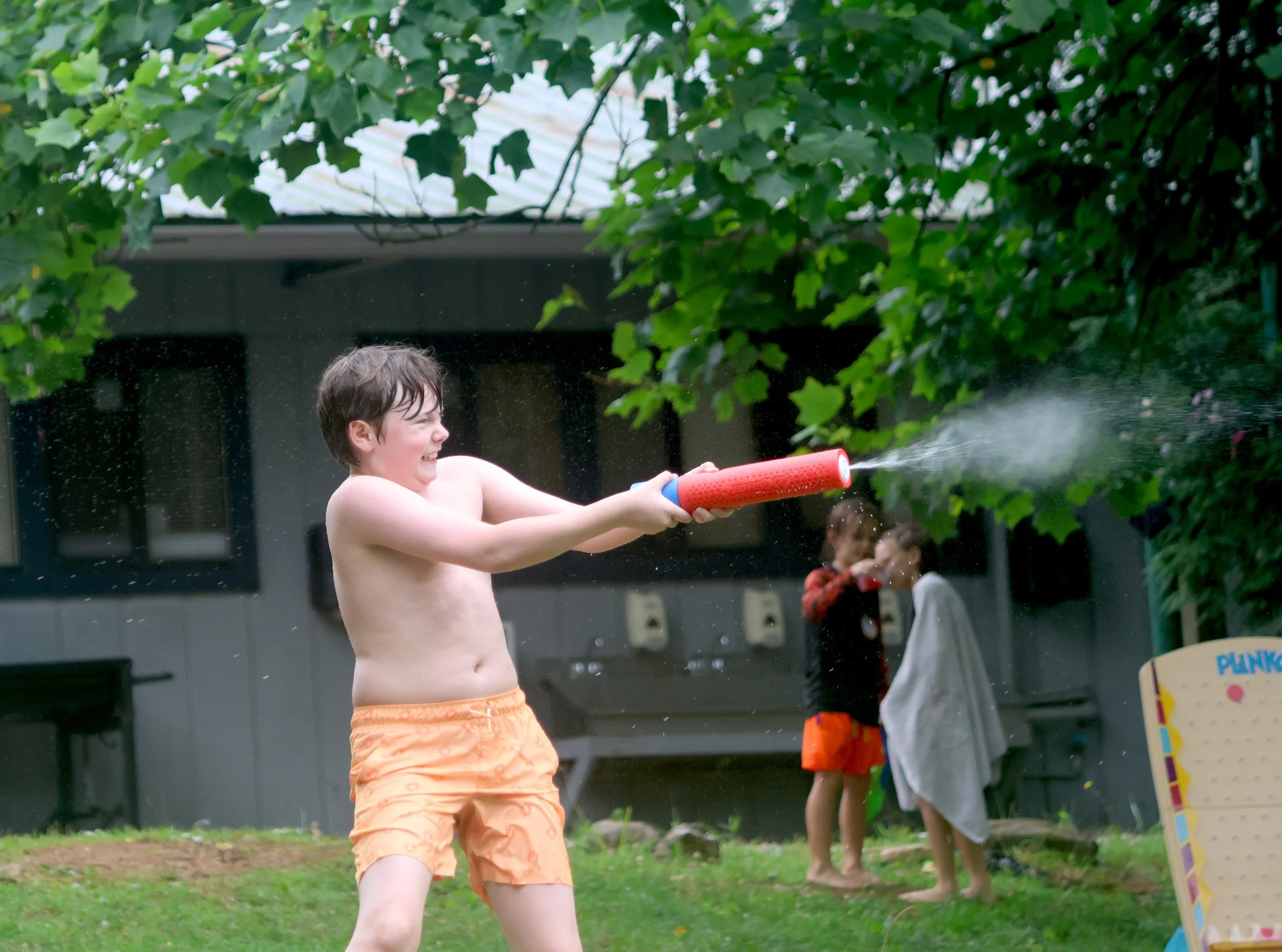 Camper at Arrowhead having fun spraying water at summer camp.