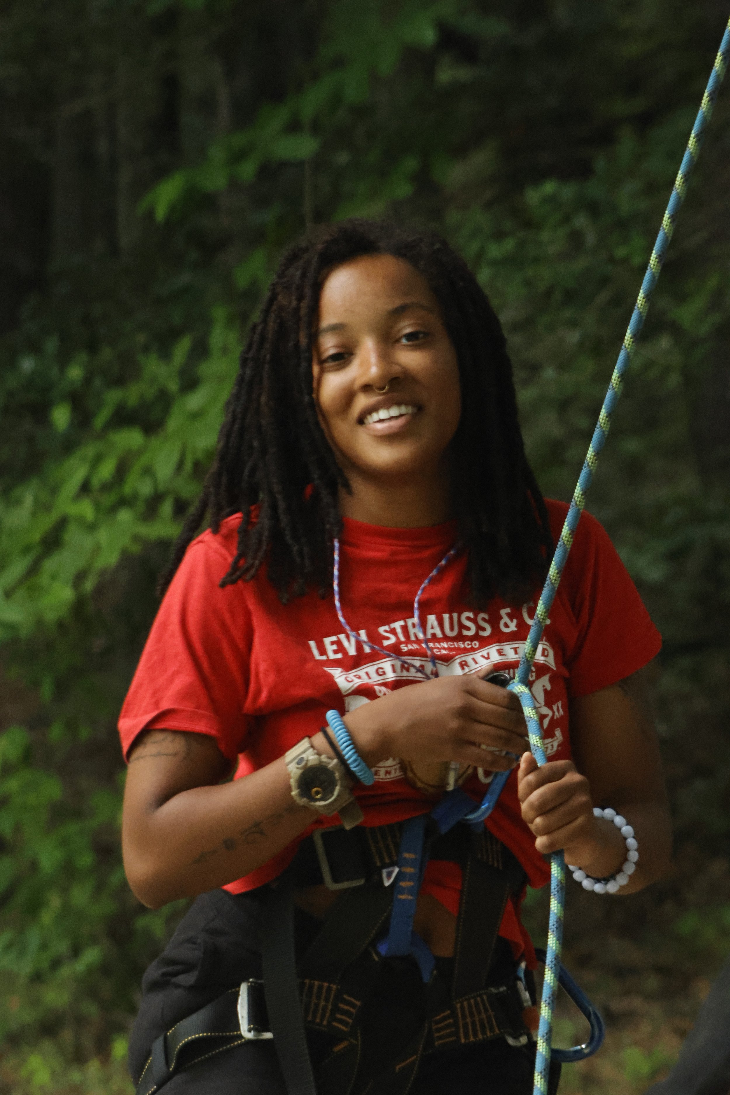 Camp Arrowhead Counselor smiles as she safely belays campers on the climbing wall in NC