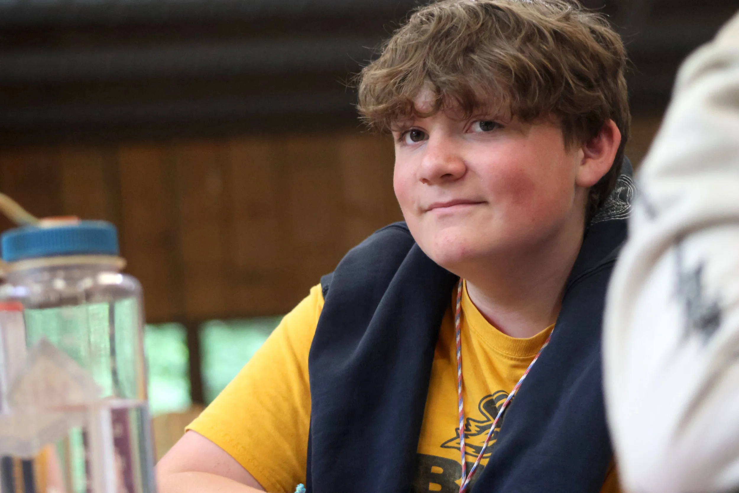 A confident older Arrowhead camper smiles while at summer camp.