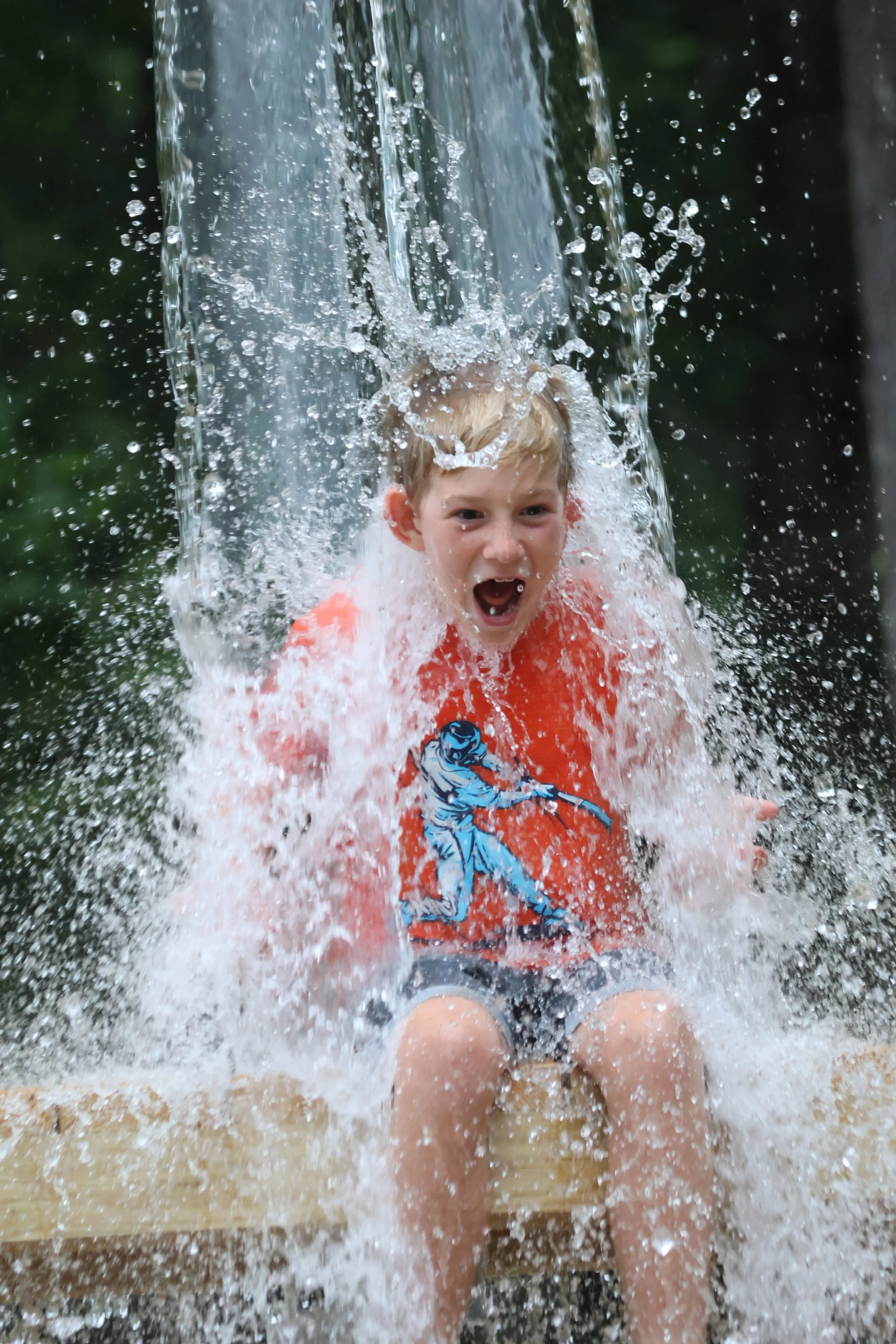 Sleepaway camper having fun when water is dumped on him at Camp Arrowhead.
