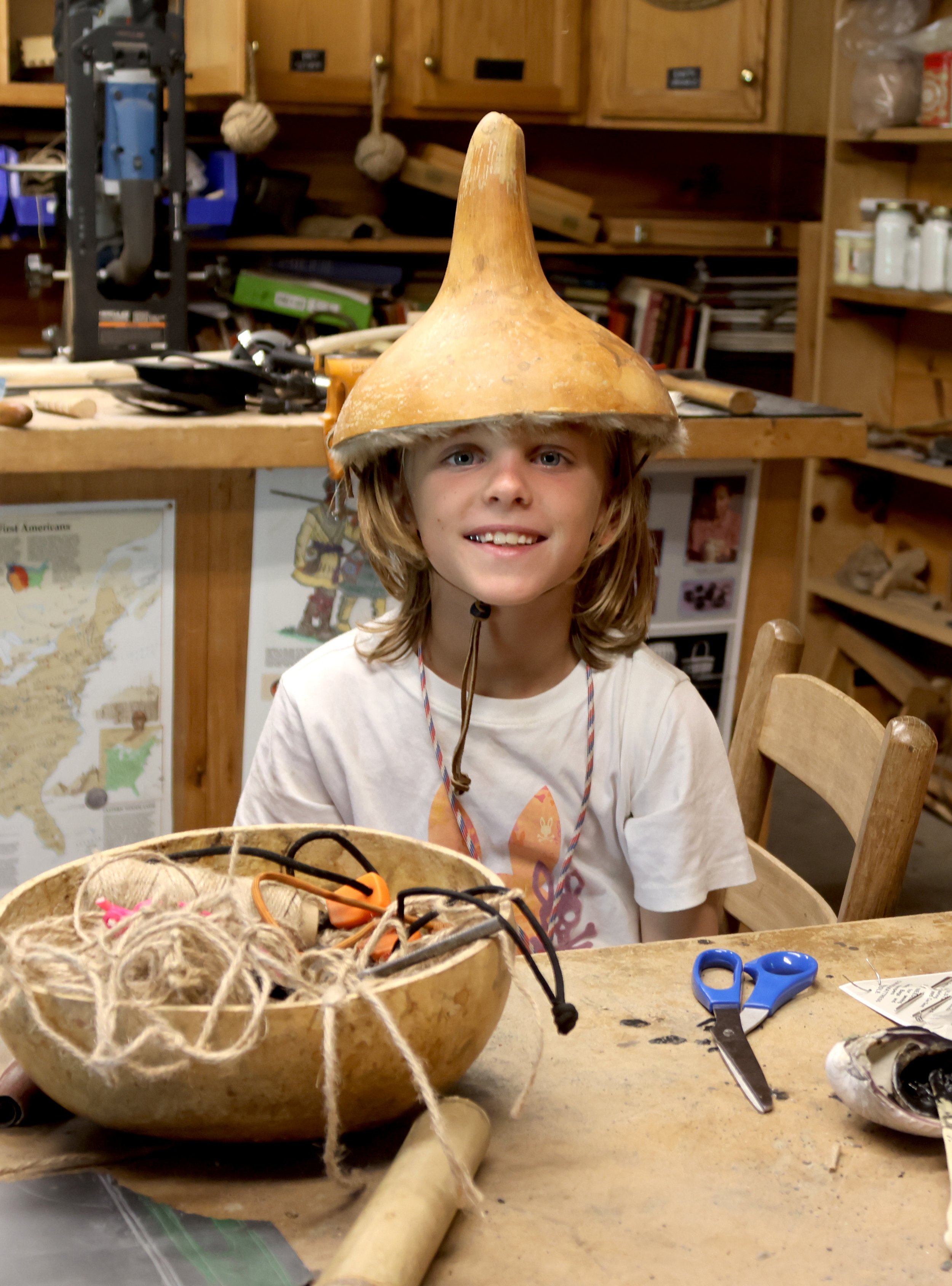 Camp arrowhead camper wearing a hat made from a gourd in bushcraft