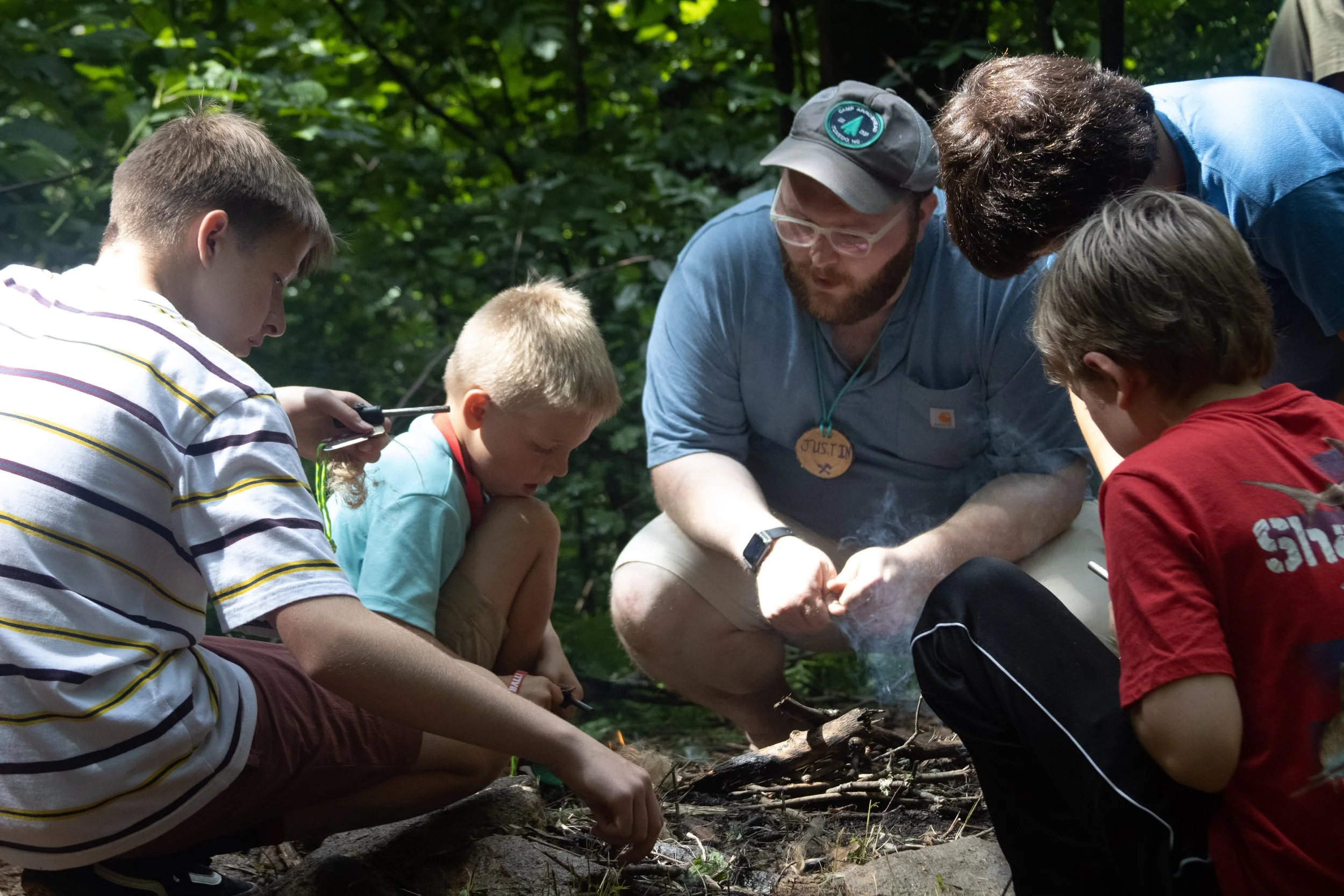Camp Arrowhead Counselor showing campers how to safely build a fire.