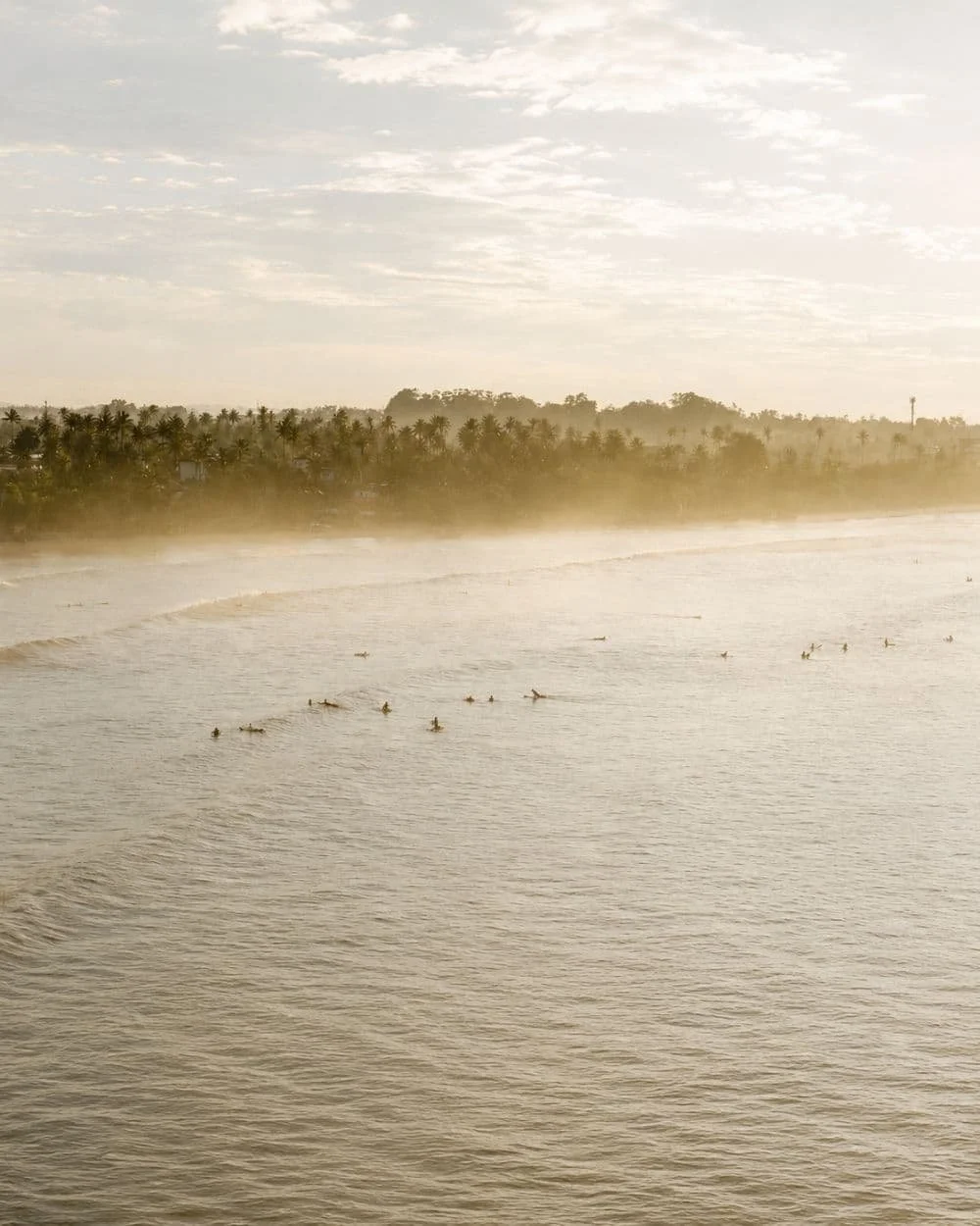 Wide view of guests sitting in a lineup with unbroken waves approaching