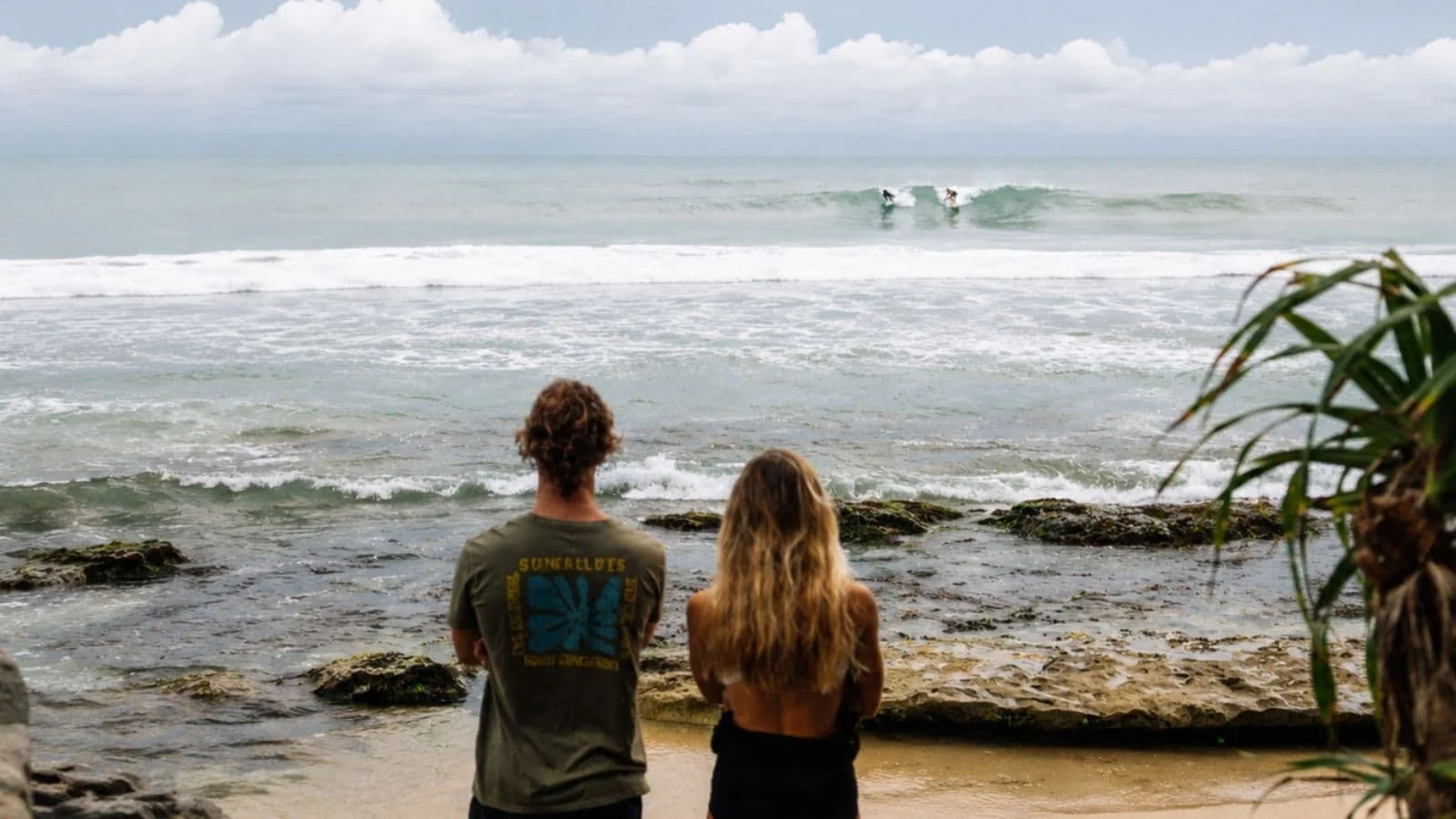Coach and intermediate guests checking a surf break before paddling out
