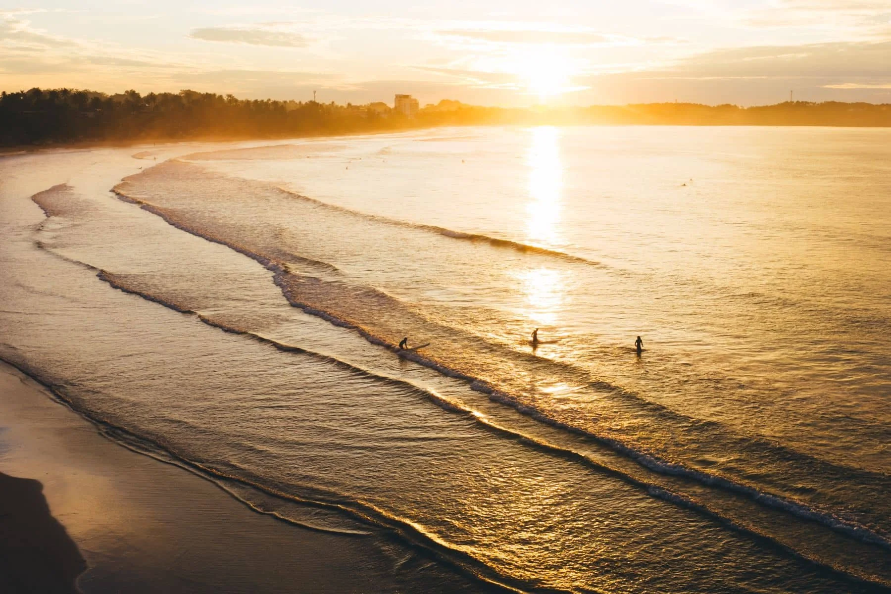 Wide view of Weligama Bay with beginner-friendly surf
