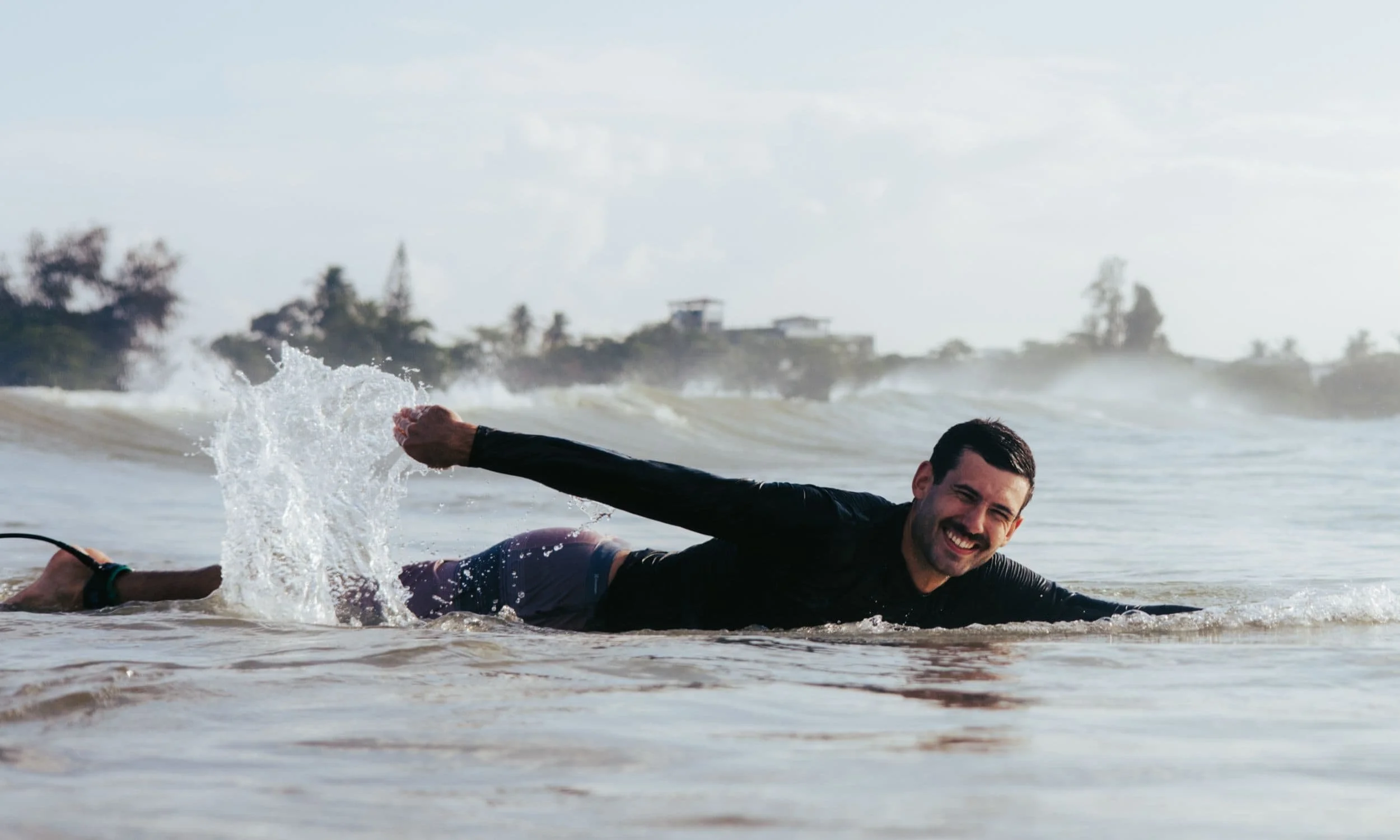 Layback guest catching a clean green wave beyond the whitewater in Weligama, Sri Lanka