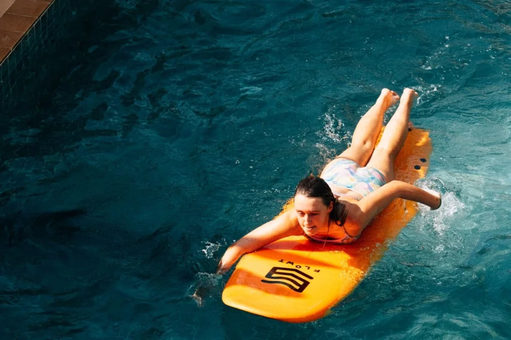 Beginner guest practising board control and safety skills in the pool