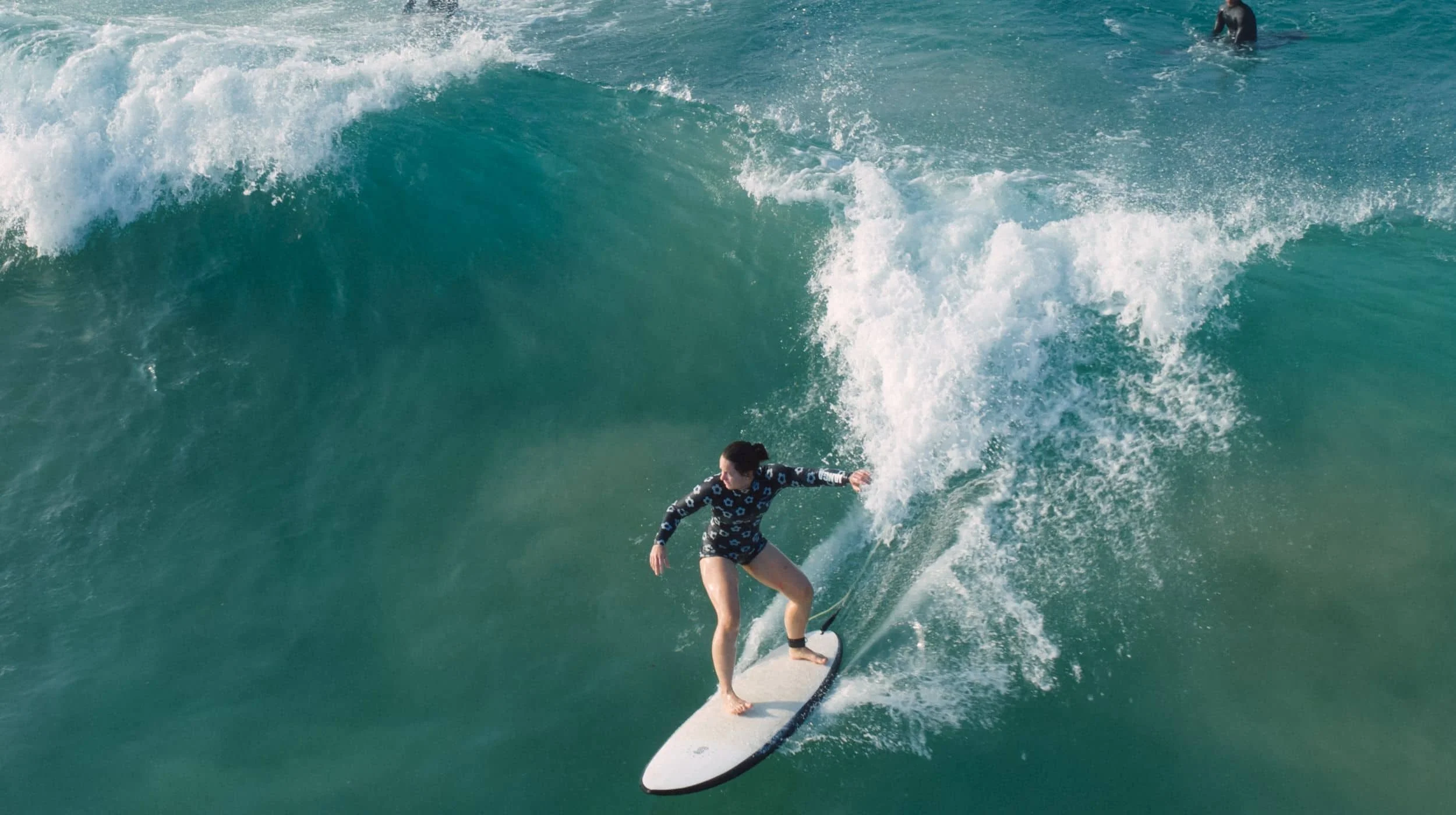 Intermediate Layback surfer generating speed and turning on a clean open-face wave in Sri Lanka