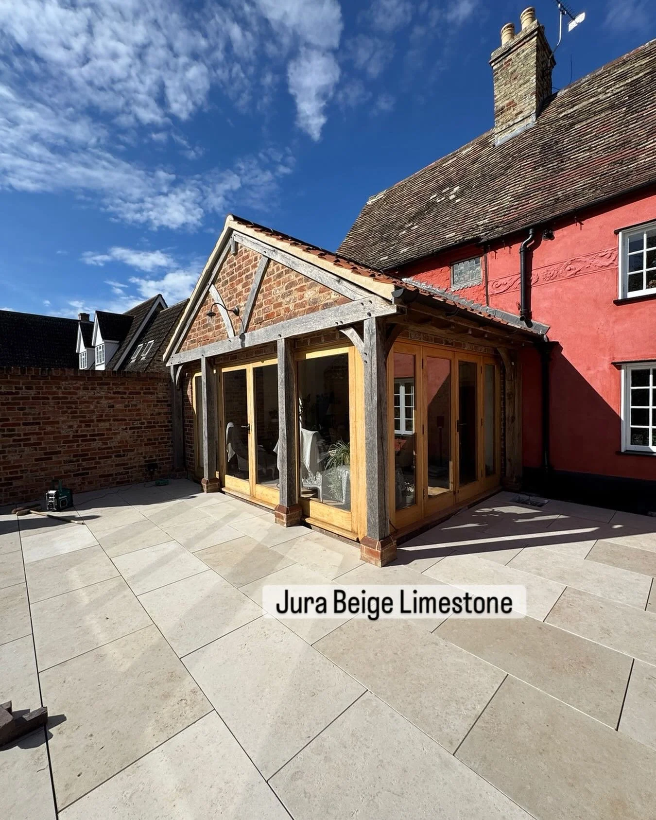 After securing planning permission for the hard landscaping in this grade 2 listed property. The patio is finally being laid and Jura beige limestone does not disappoint. Looking absolutely stunning against the blue skies and red house. #londonstone 