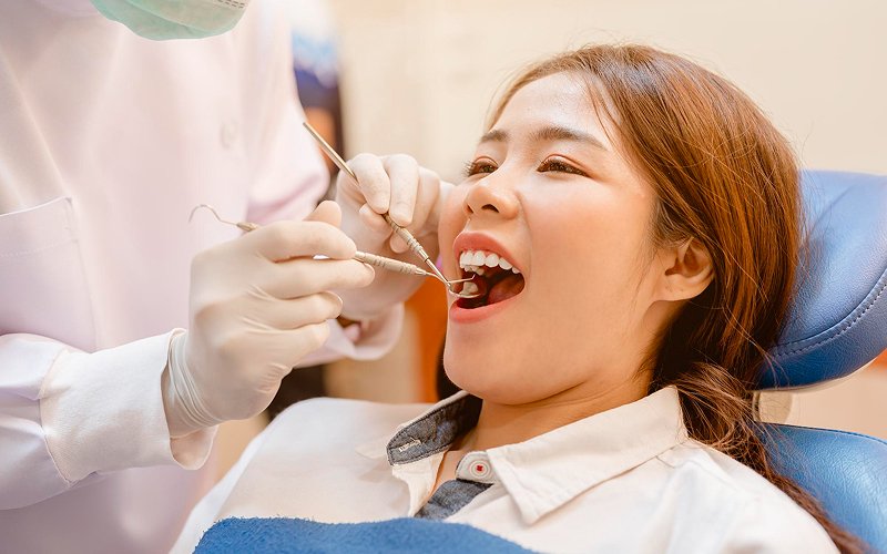 Dentist examining patient profile for bimaxillary protrusion treatment assessment.