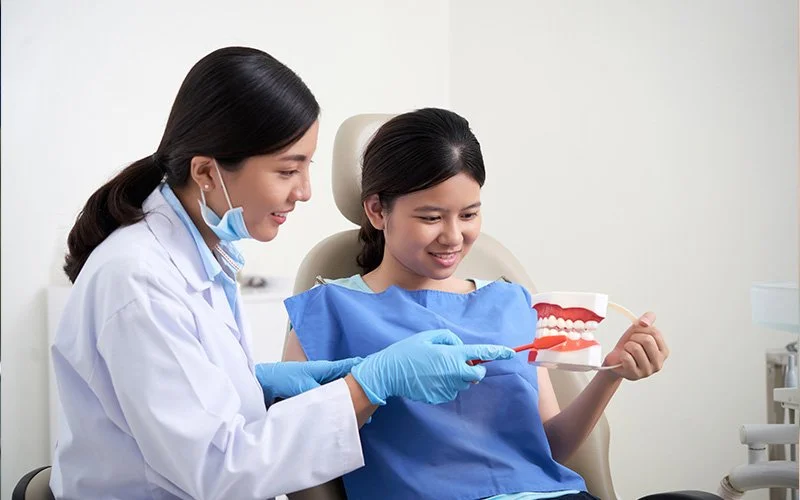 a dentist showing teeth model to her patient