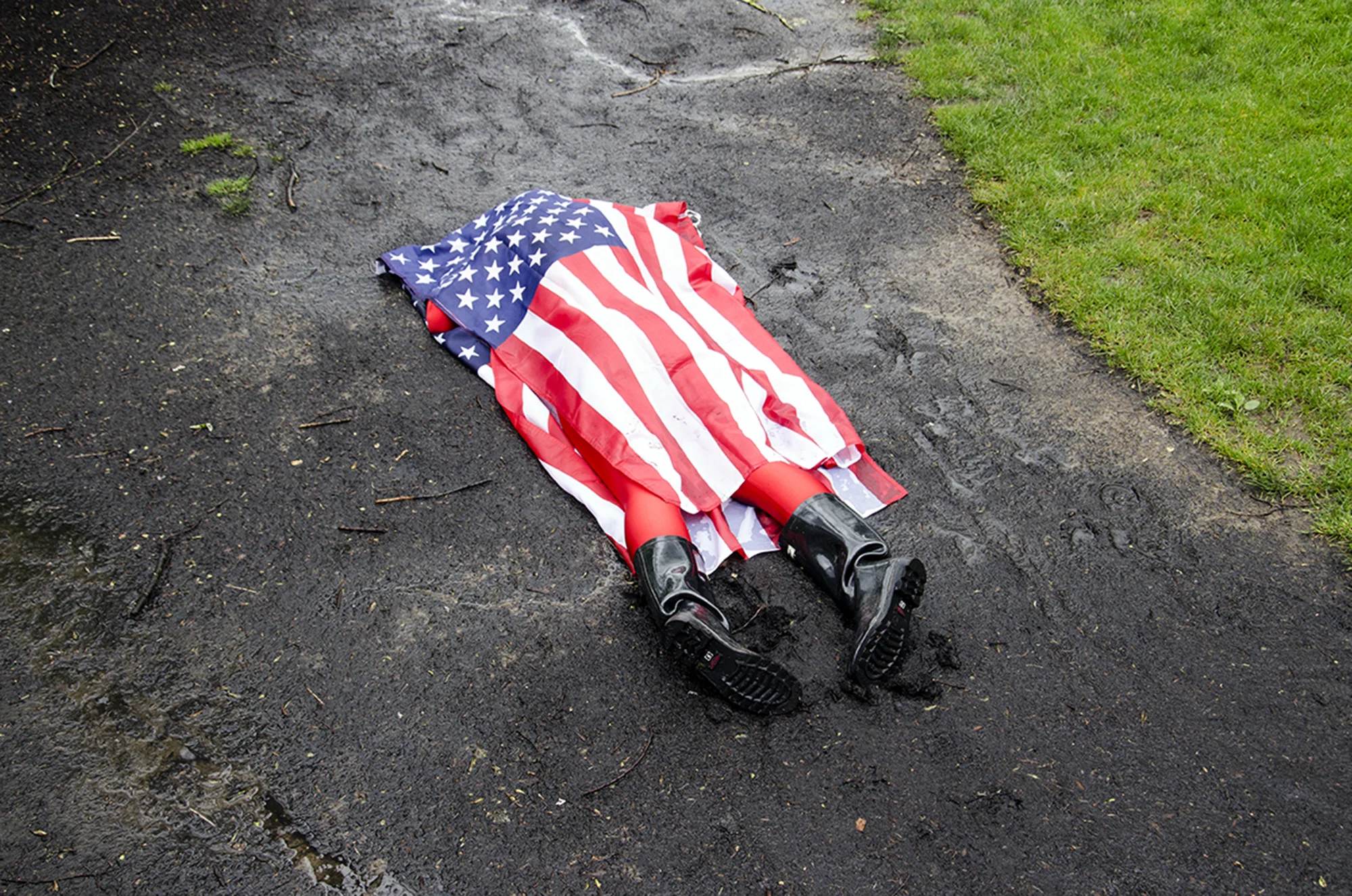 Lying in the Mud covered w/ American Flag Performance, OCGOPF (Open Call Guerrilla Outdoor Performance Festival), 2017.