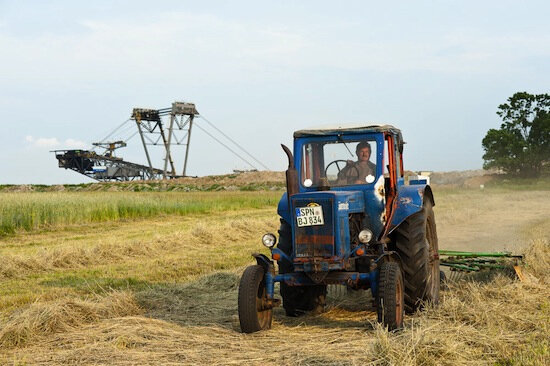 Frank Döring, Untitled (Farmer turning hay in view of coal extractor), 2009, Archival pigment print, 18 x 25.5 inches