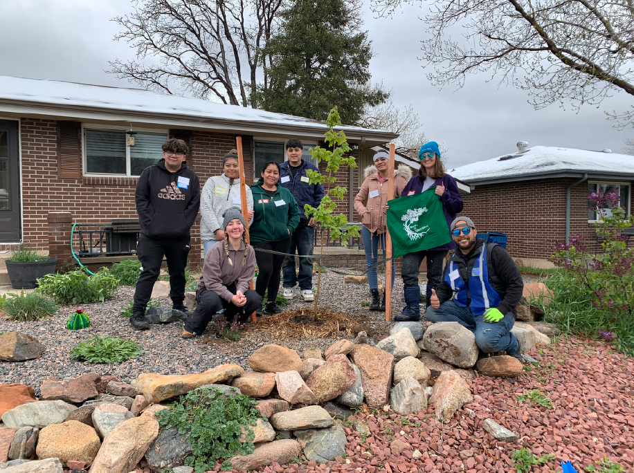 Volunteers pose with a tree.
