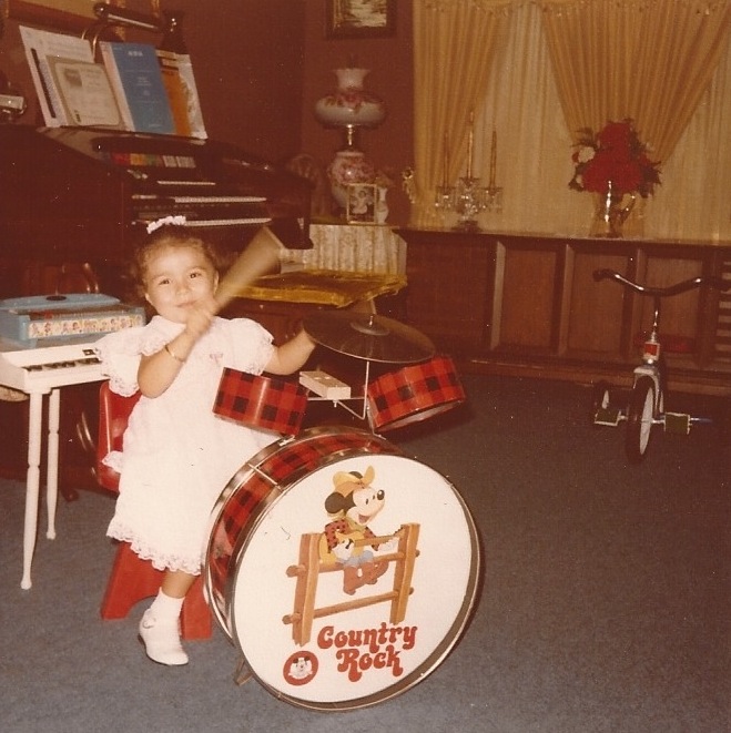 Angie playing the drums at age 3