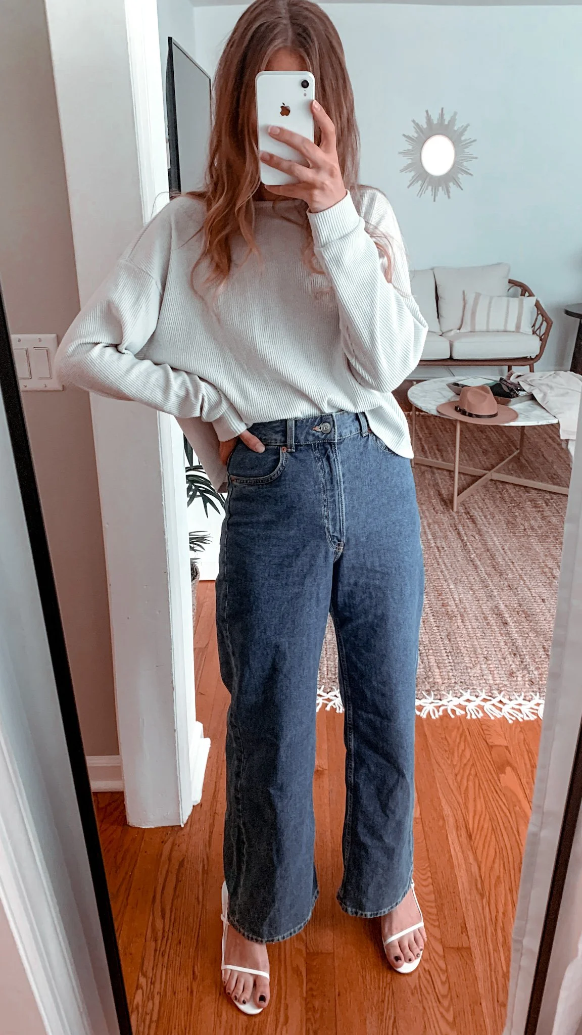 woman wearing medium wash wide leg jeans with a french tucked sweater