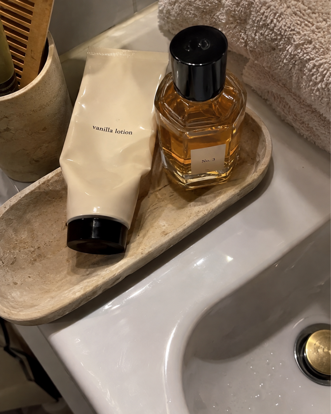 a vanilla lotion next to perfume on a counter