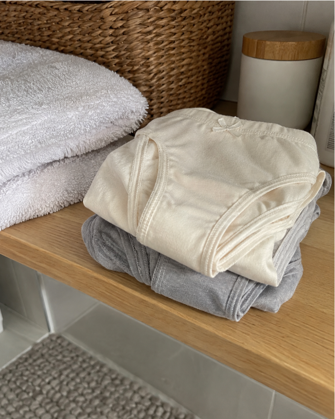Fresh cotton underwear and a clean towel on a bathroom shelf