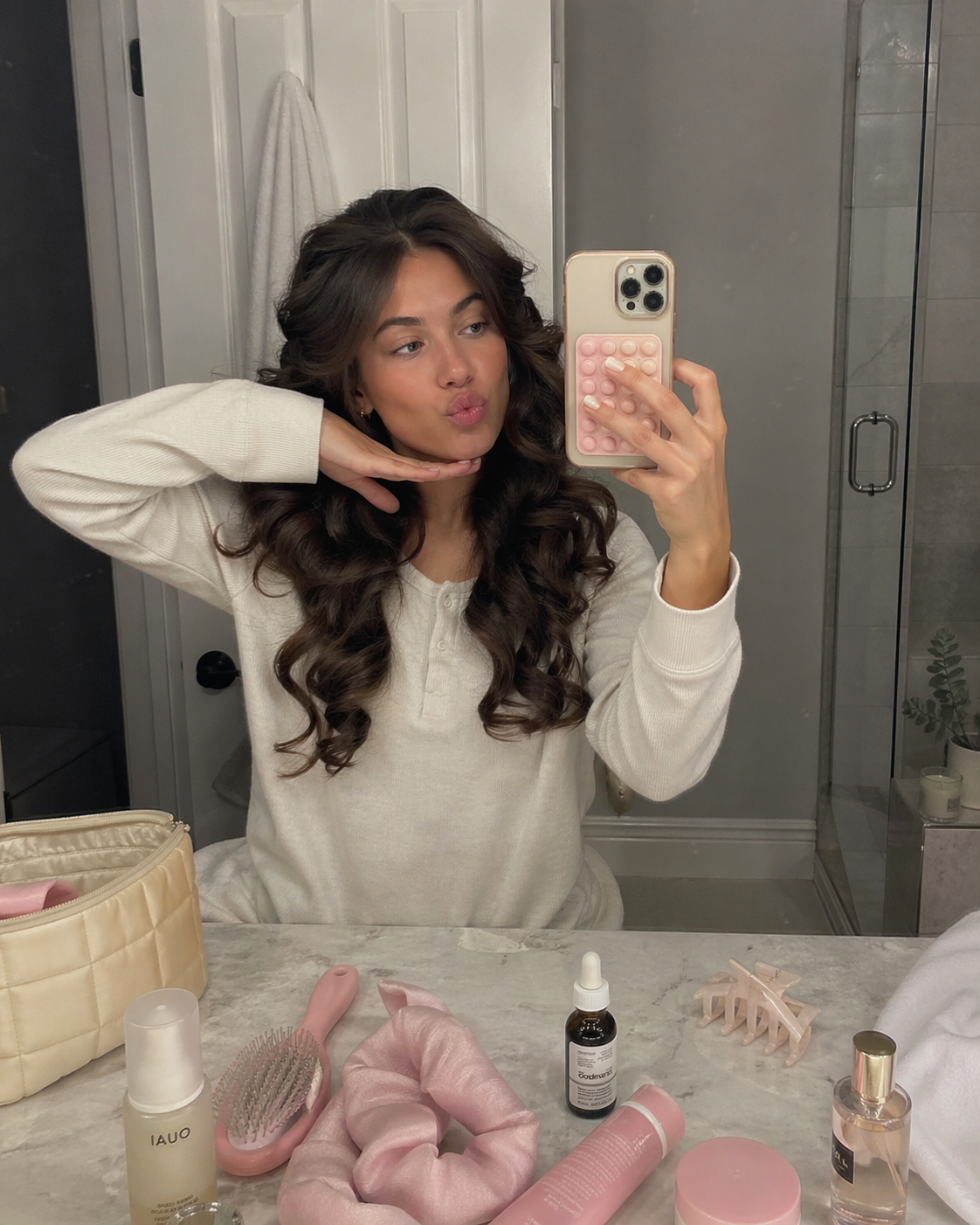 woman making a kissy face taking a mirror selfie in a bathroom