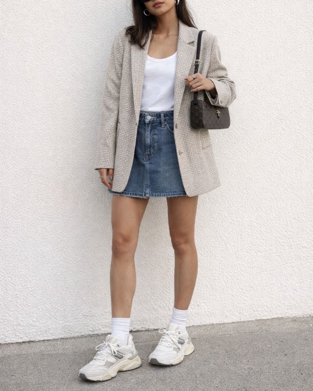 woman wearing a blazer, skirt and sneakers outfit