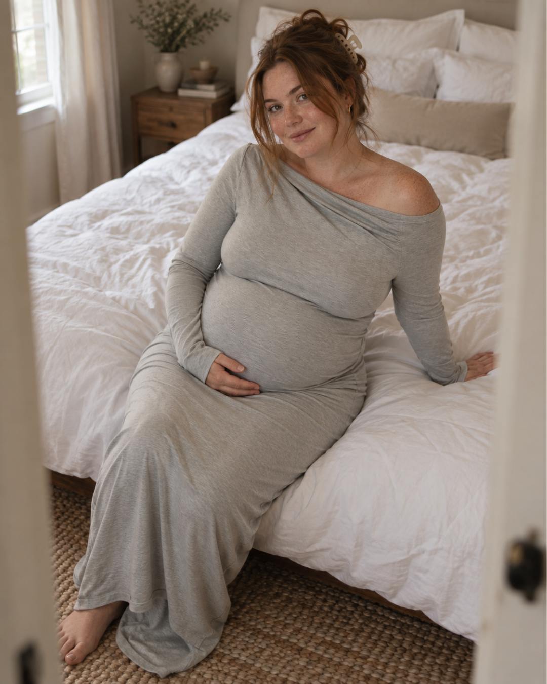 Gray maxi maternity dress seated on bed