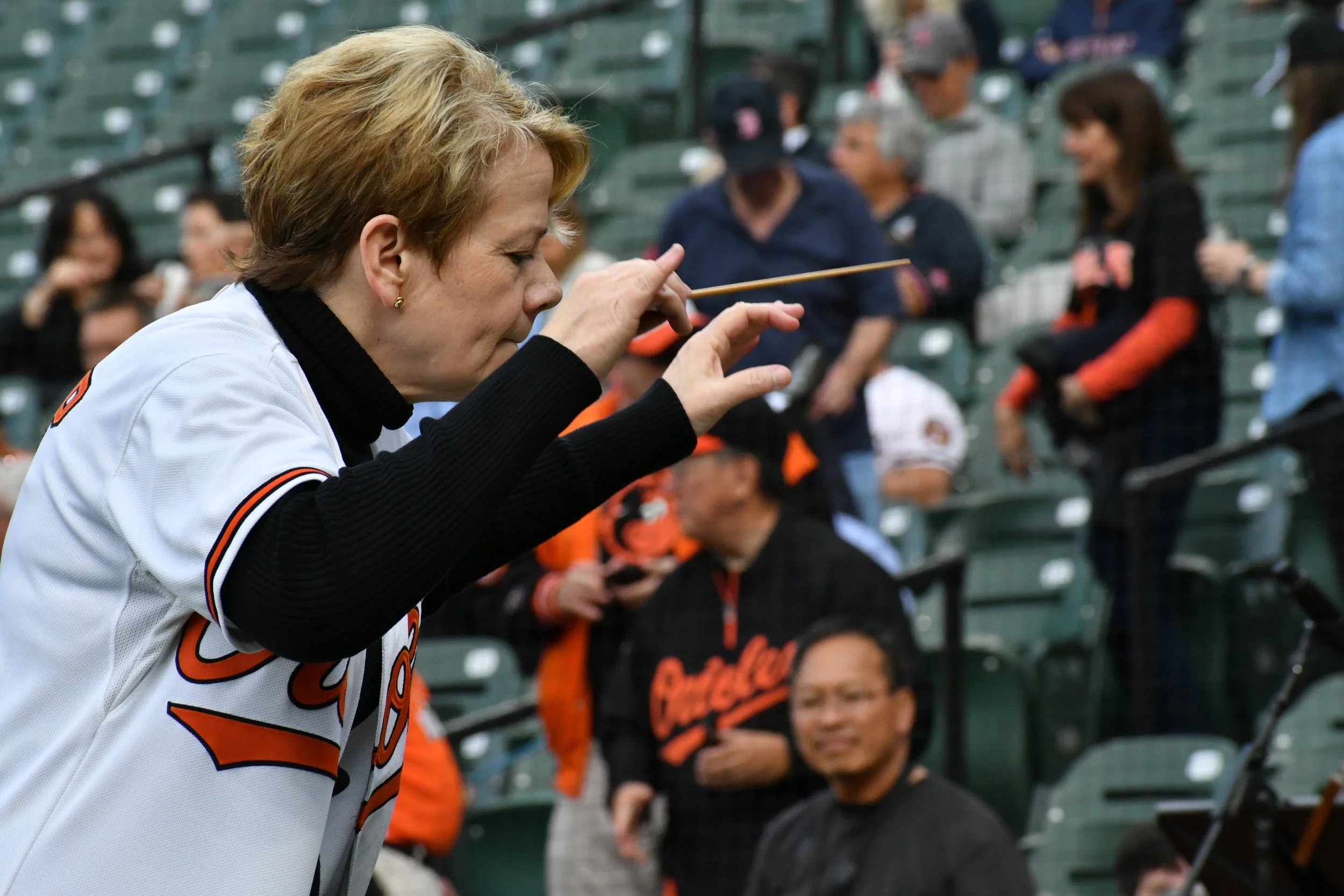 Marin Alsop leads the BSO in the national anthem before a Baltimore Orioles game