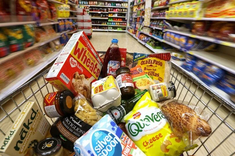Groceries-in-a-shopping-trolley-move-through-a-food-aisle.jpg