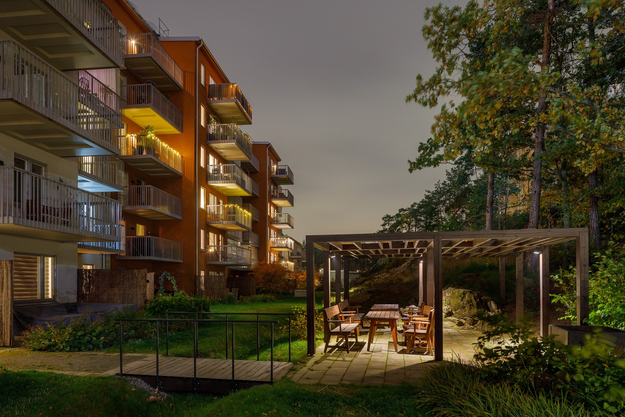 Bakgård med pergola i bostadskvarteret Grönkulla kvällstid