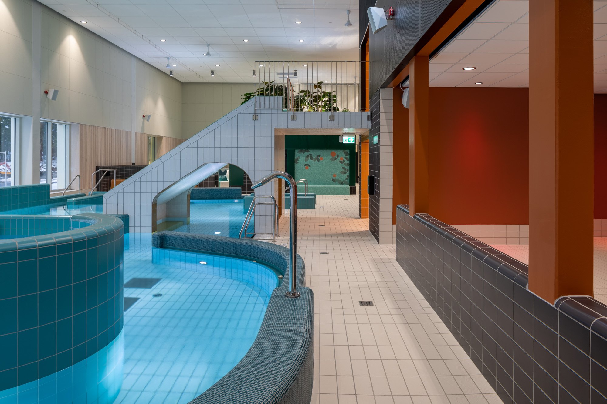 Interiörbild på familjebadet i Täby Simhall med fin ljusdesign och vacker mosaik