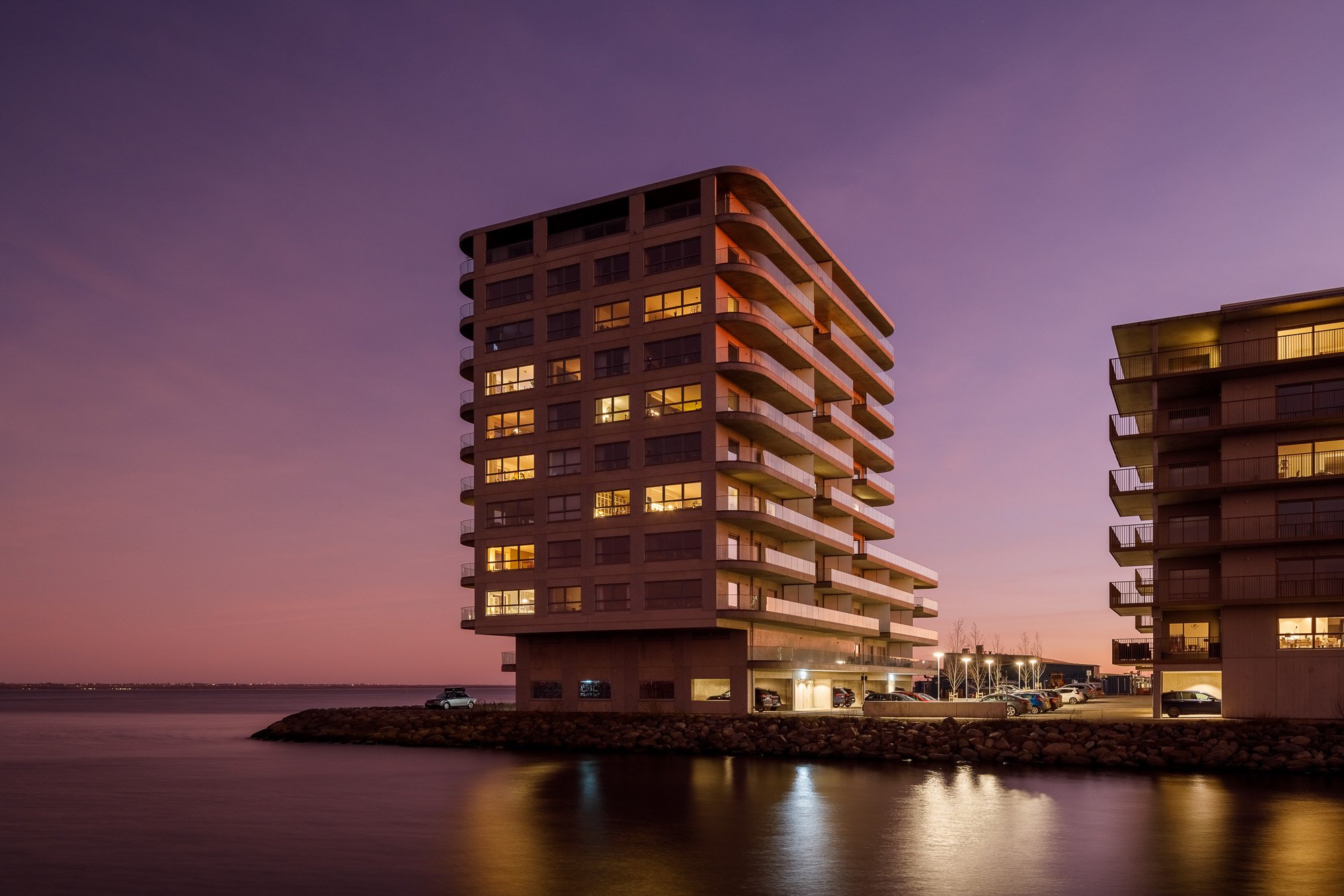 Kv Tampen nybyggt flerbostadshus vid vattnet i kvällstid med rosa himmel
