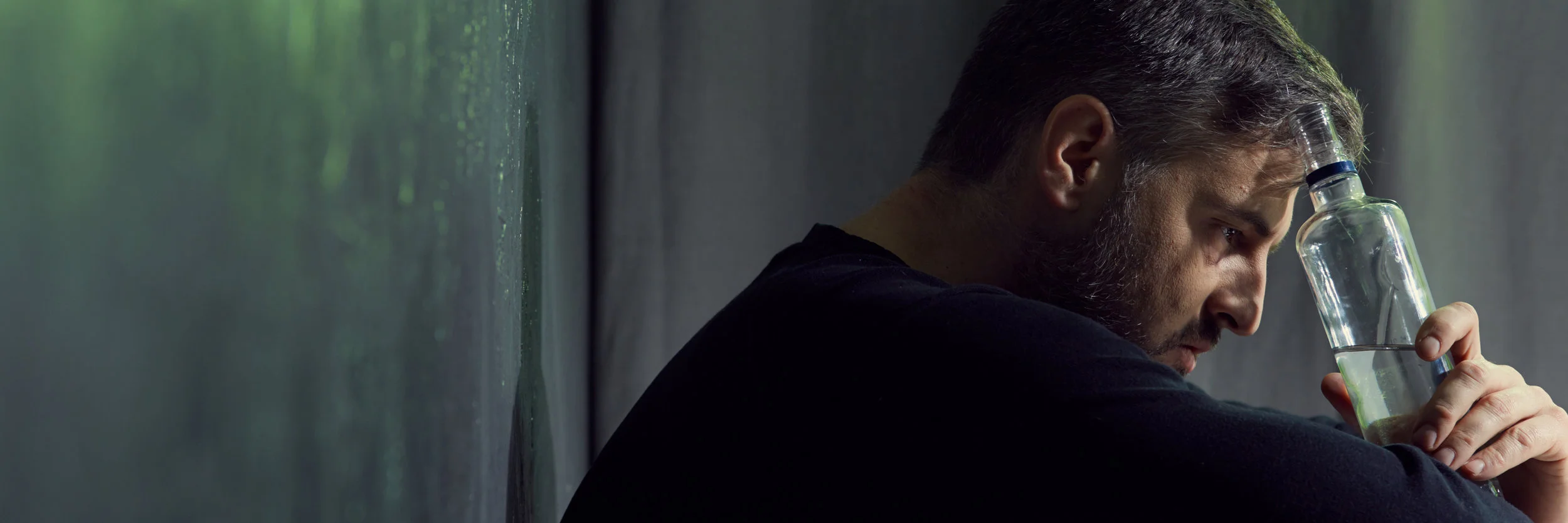 hopeless-man-holding-alcohol-bottle-P4US4DH.jpg
