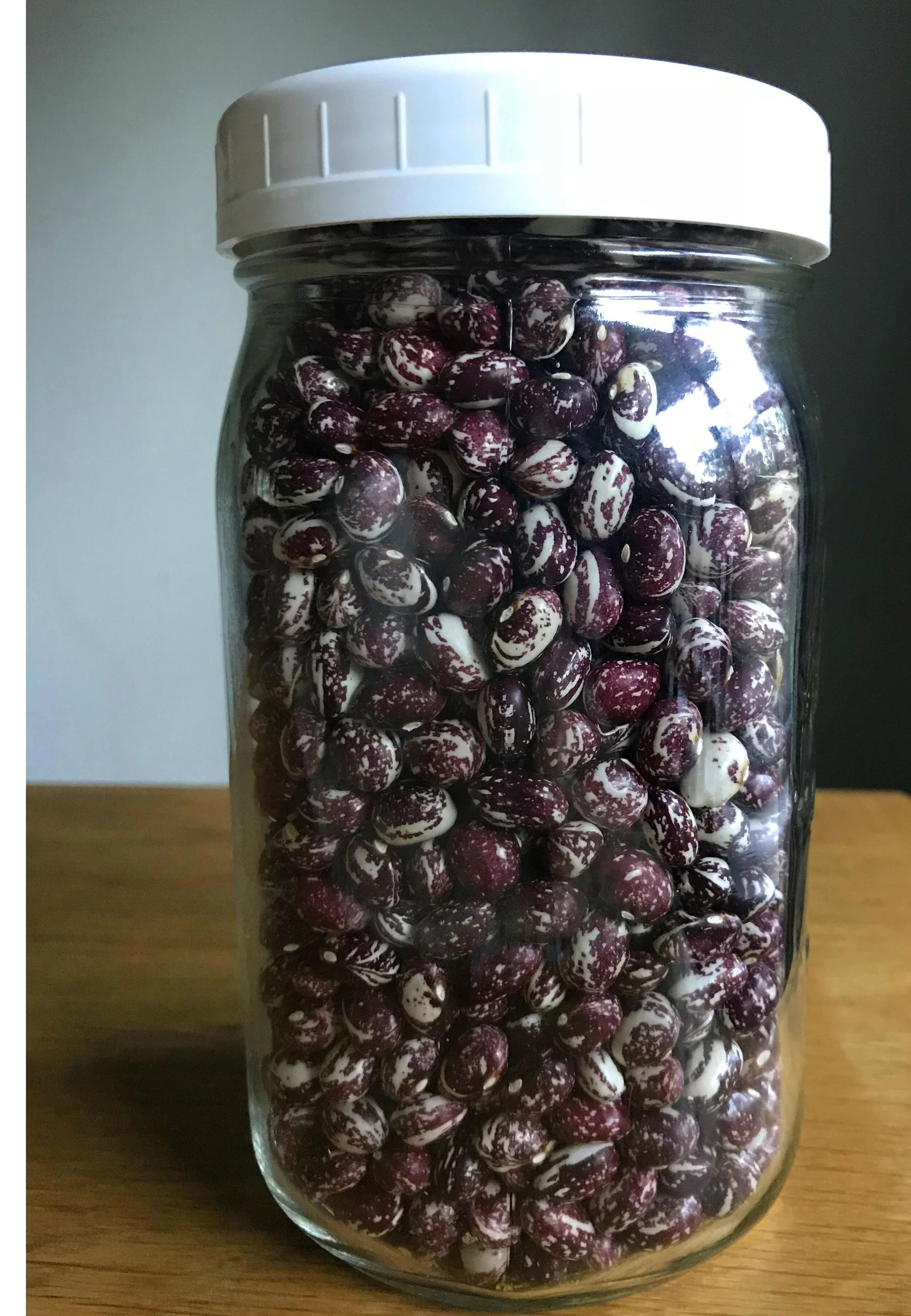 Dried red and white Good Mother Stallard beans in a mason jar with a lid.