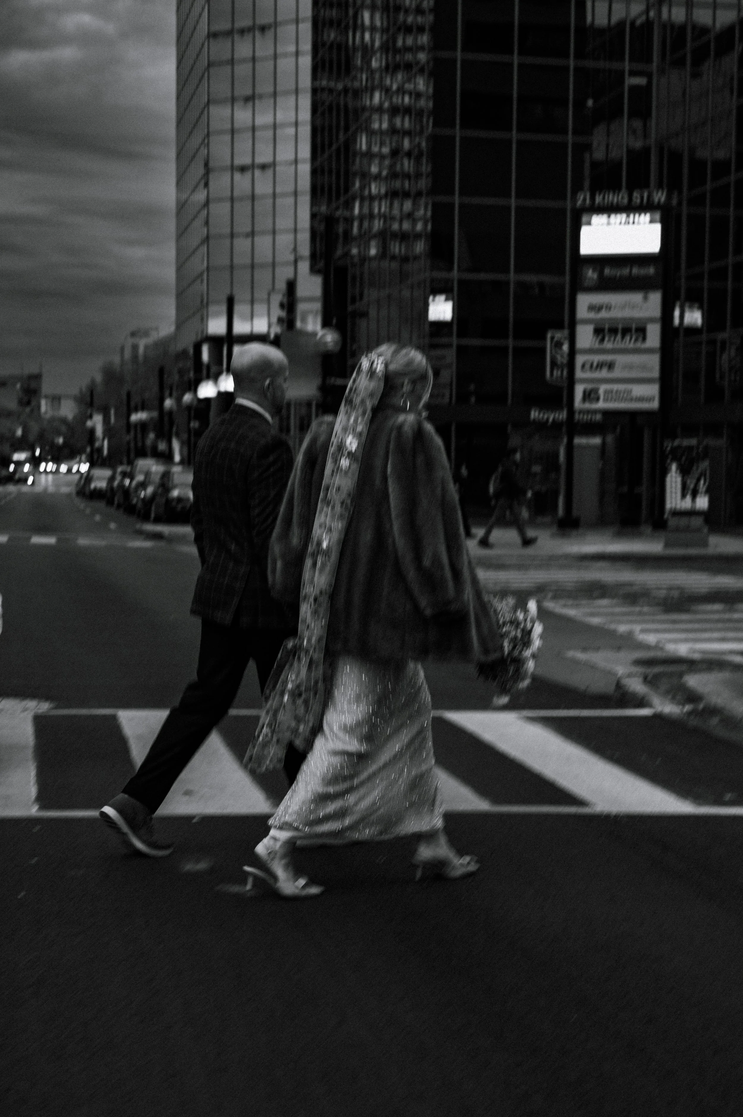 Documentary wedding photography in Hamilton, Ontario: a moody image of the bride and groom walking to their wedding venue in Hamilton.