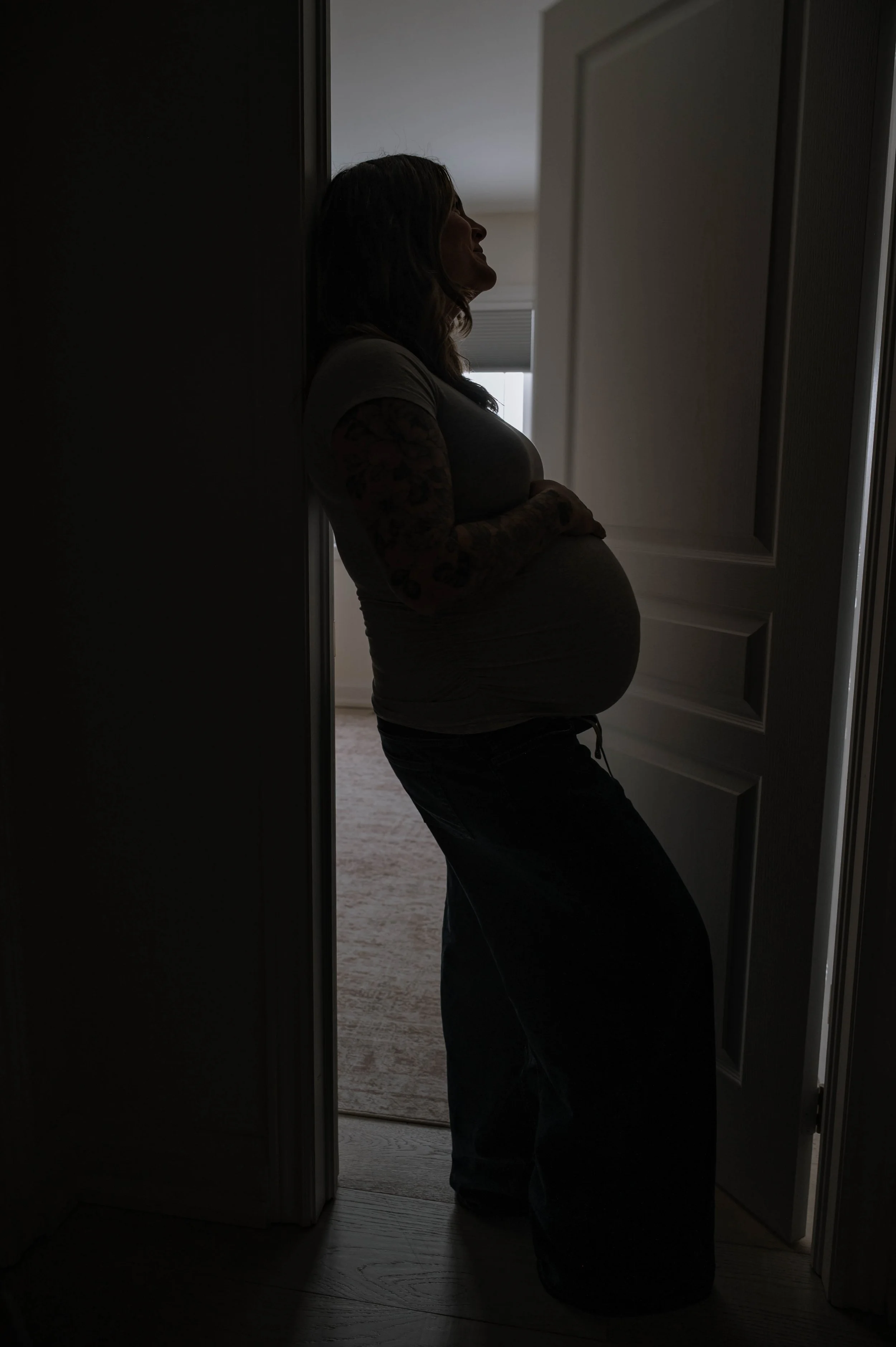 A silhouette of a pregnant woman during a lifestyle in-home maternity session.