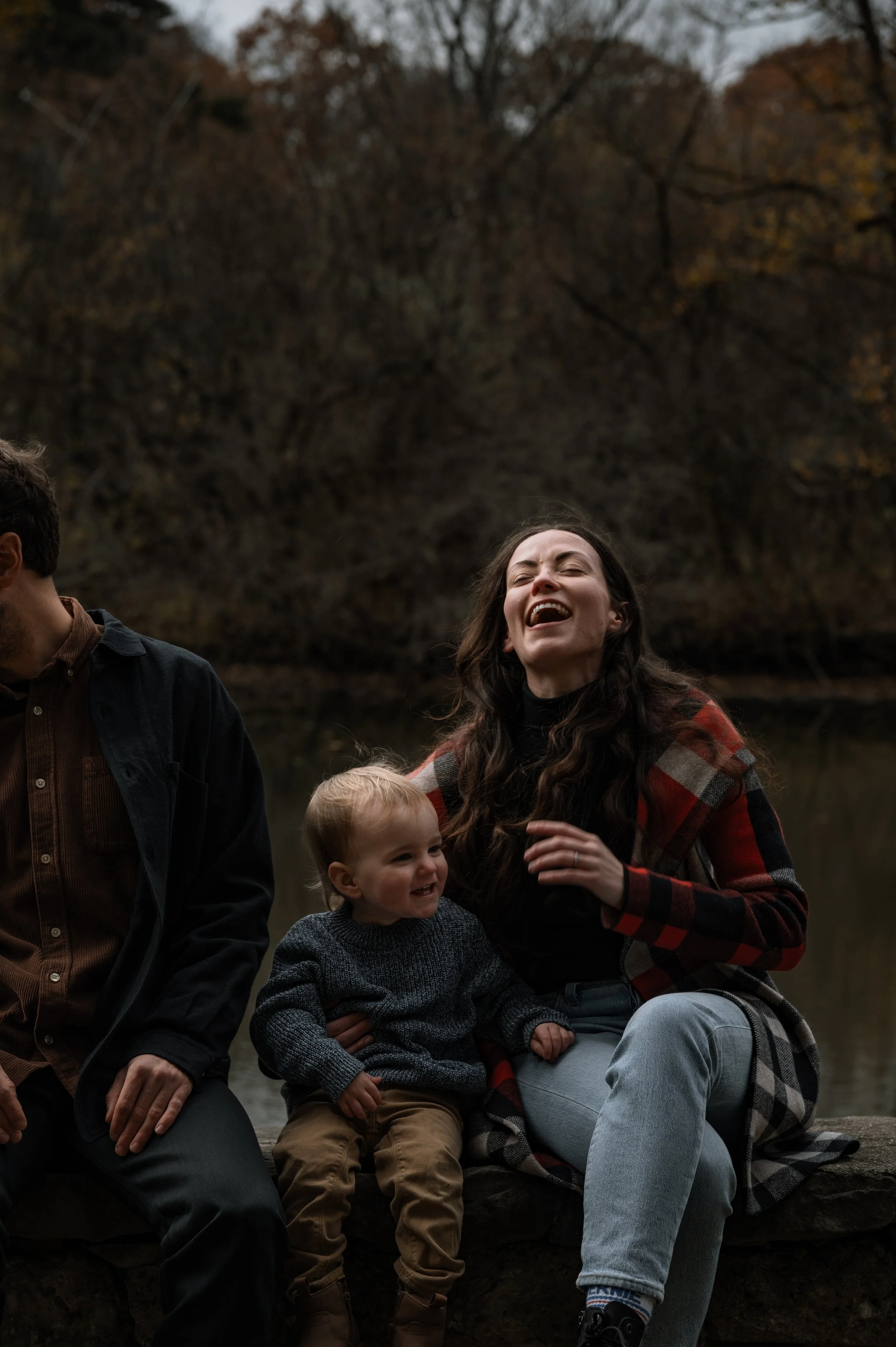 A candid, unscripted moment of a mother and toddler laughing during a documentary family photography session in Toronto.