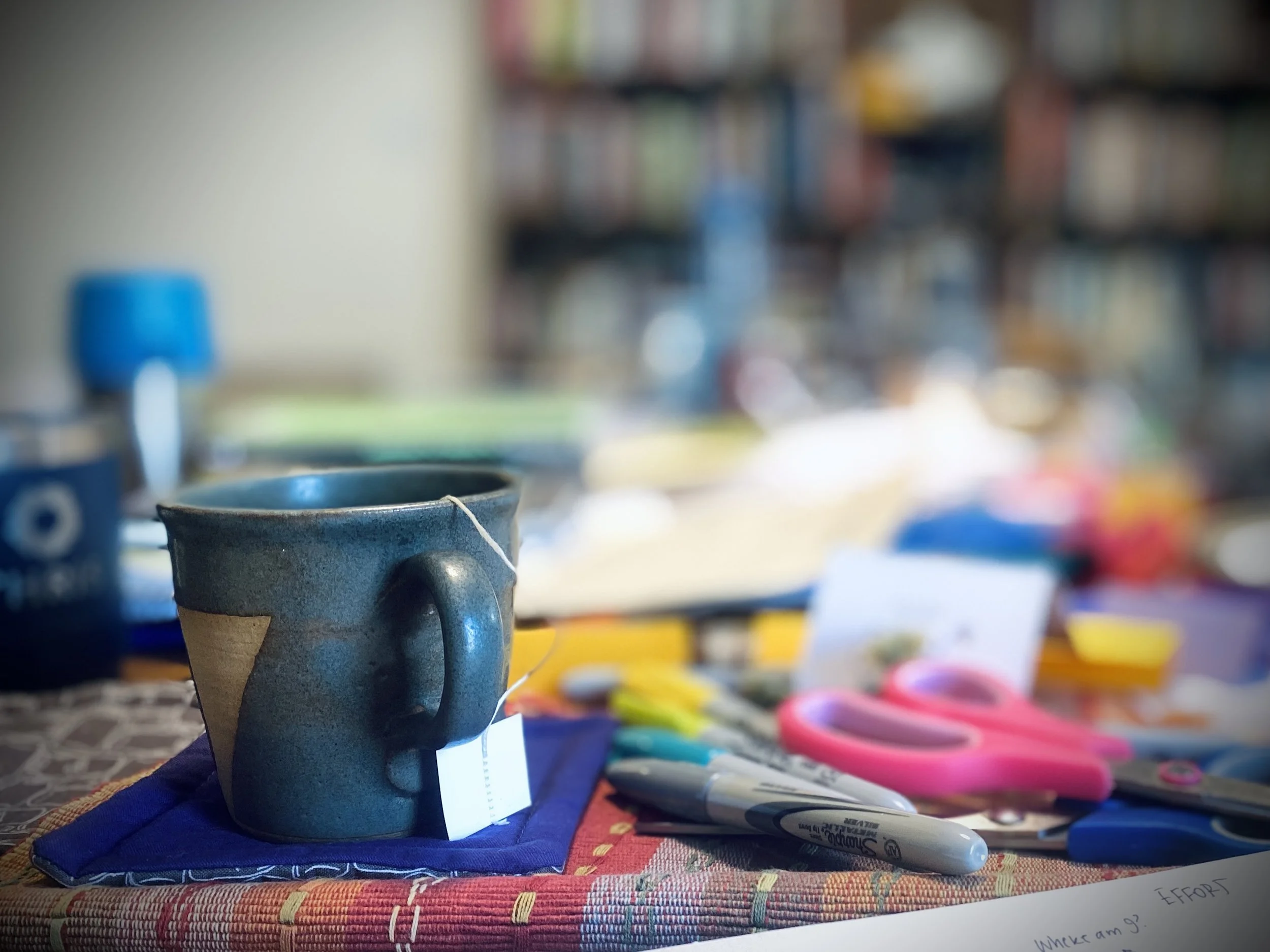 A messy pile of office supplies and a mug of tea