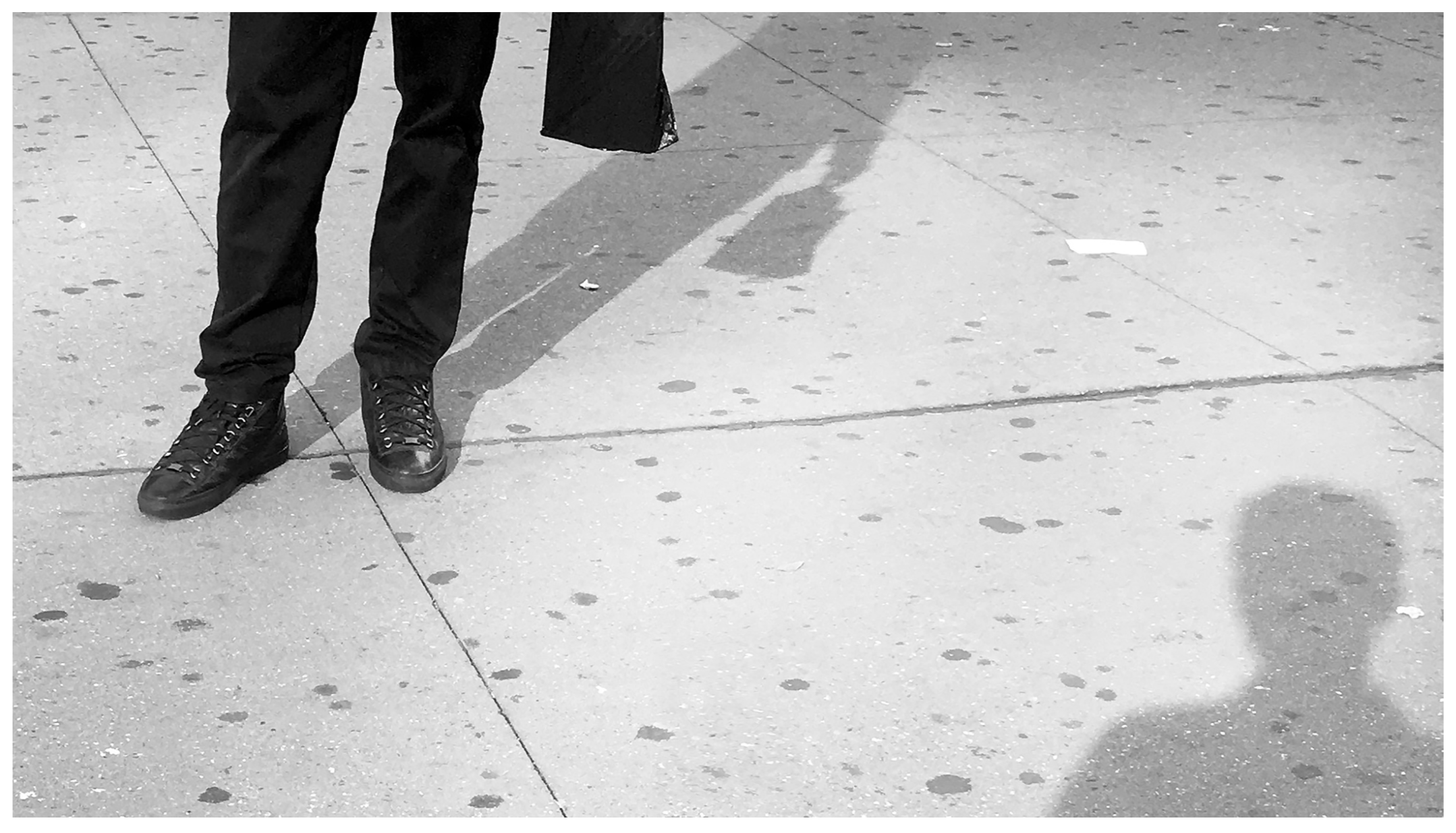 Distance, 2017, Jet Print, Premium Photo Satin 240gsm, 9.6 in x 16.5 in “Expecting to make friends with natives, but end up being hesitated to take an action and stand aside.” This subtle feeling of distance be-tween the foreign and the local has often been running upon some of those who recently reside far away from home. The work captures a tiny portion of human body and shadow, simplifying and signifying the subjects, which stimulates viewers to imagine a larger picture outside the frame: the shadows indicate face-to-face body gesture located out-side the photo, suggesting the expectation to communicate with each other; however, one of them moves away his sight, staring at the legs of the other person instead. The anticipation of communication and the betray of action create this invisible distance in-between, reflecting the hesitation in the mind.