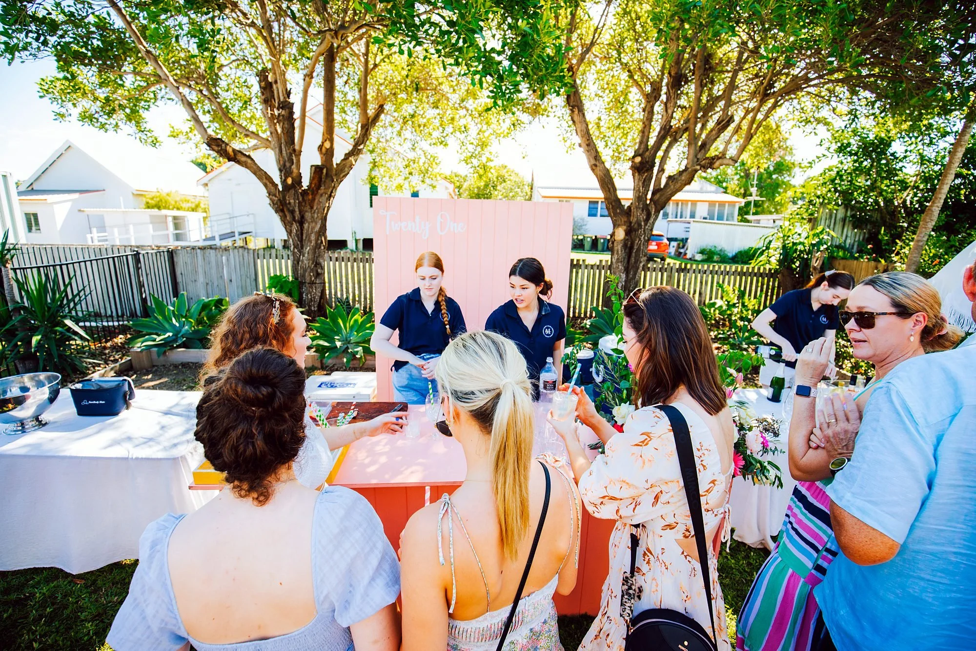 Guests enjoying a garden party with Michels staff serving from a catering station