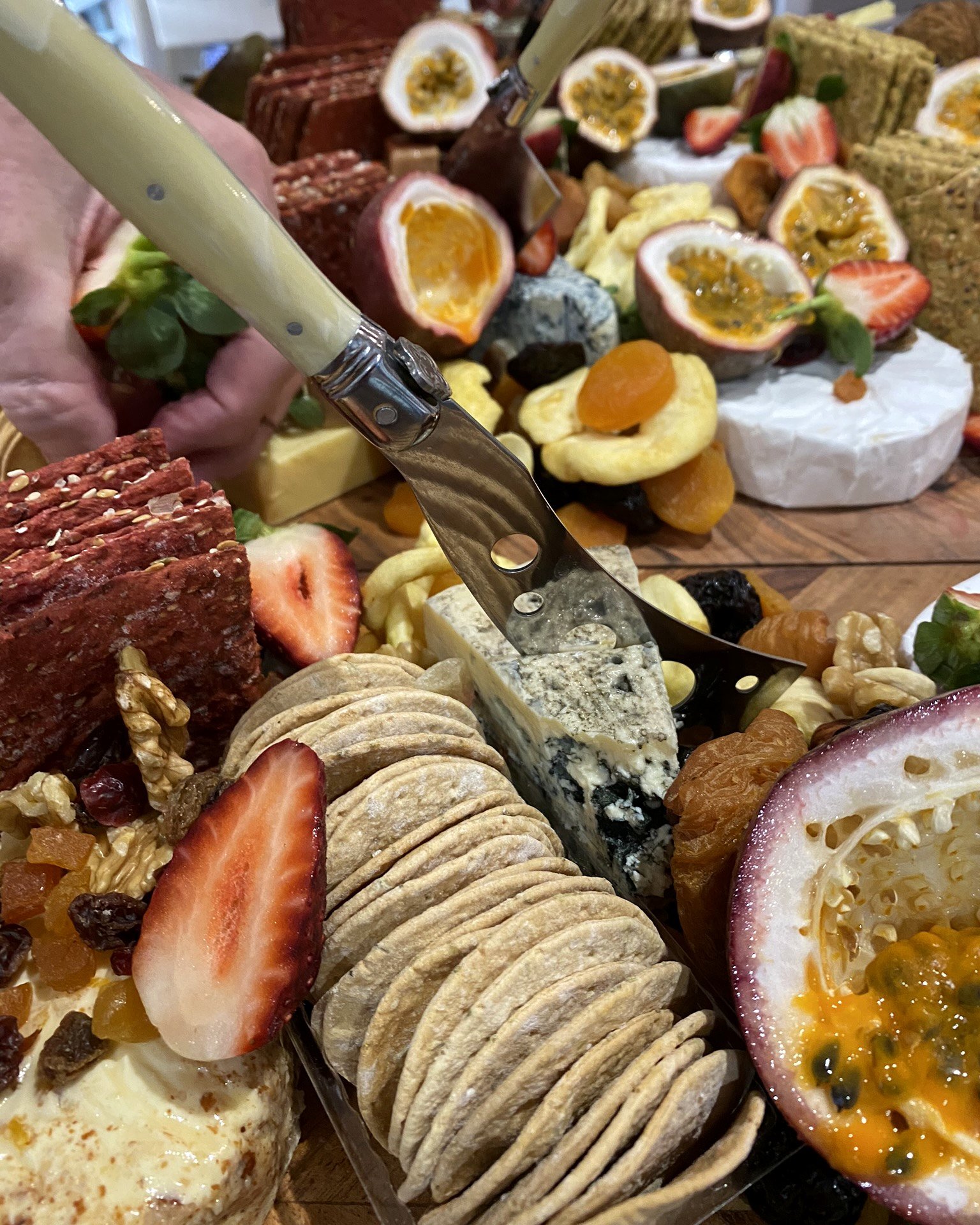 Grazing display of cheeses, passionfruit, strawberries and crackers
