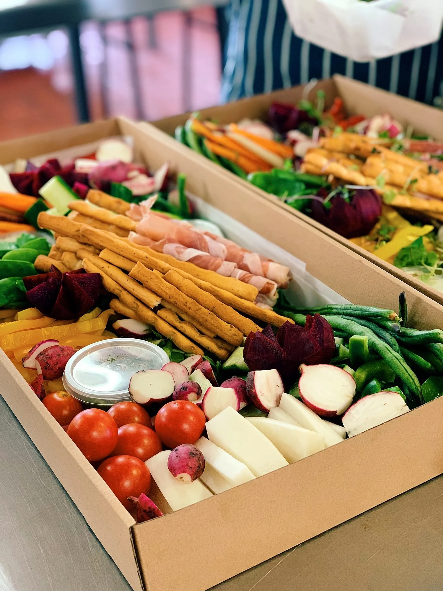 Conference lunch box of grissini, crudités, charcuterie and fresh fruit